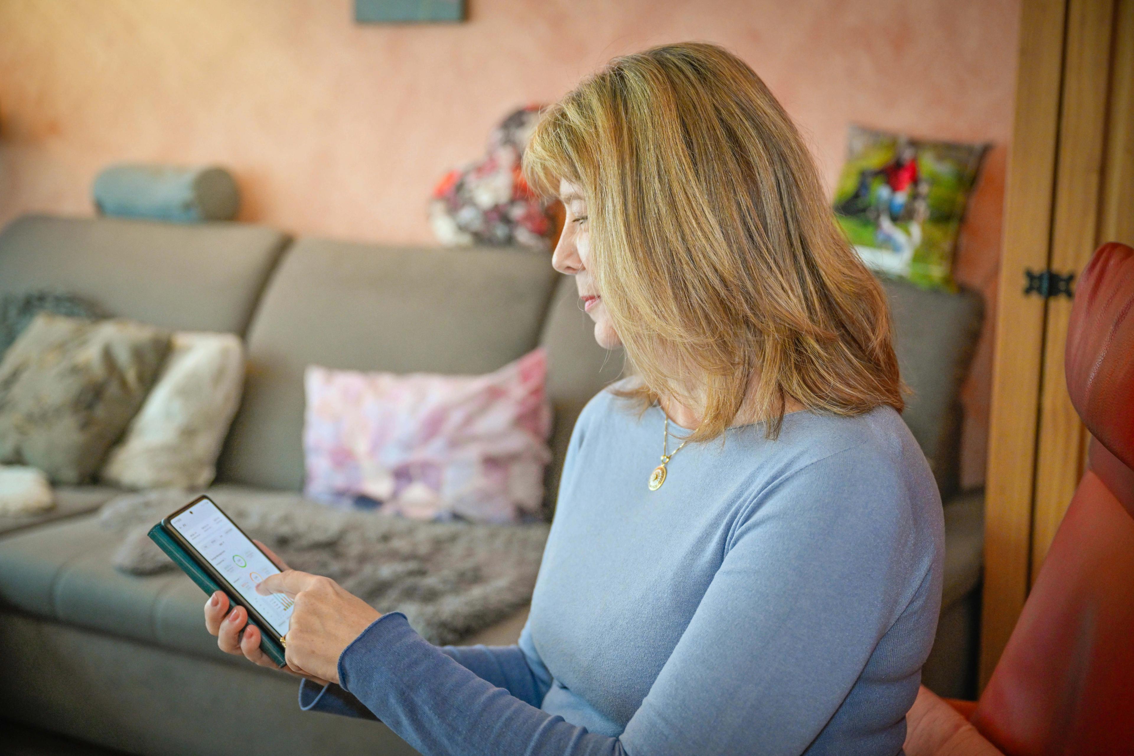 Eine Frau, die sich mit ihrem Tablet bei Otovo MyPage anmeldet.