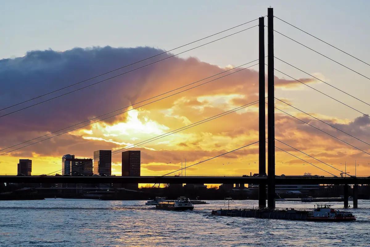 Eine Brücke über den Rhein in Nordrhein-Westfalen im Sonnenuntergang.
