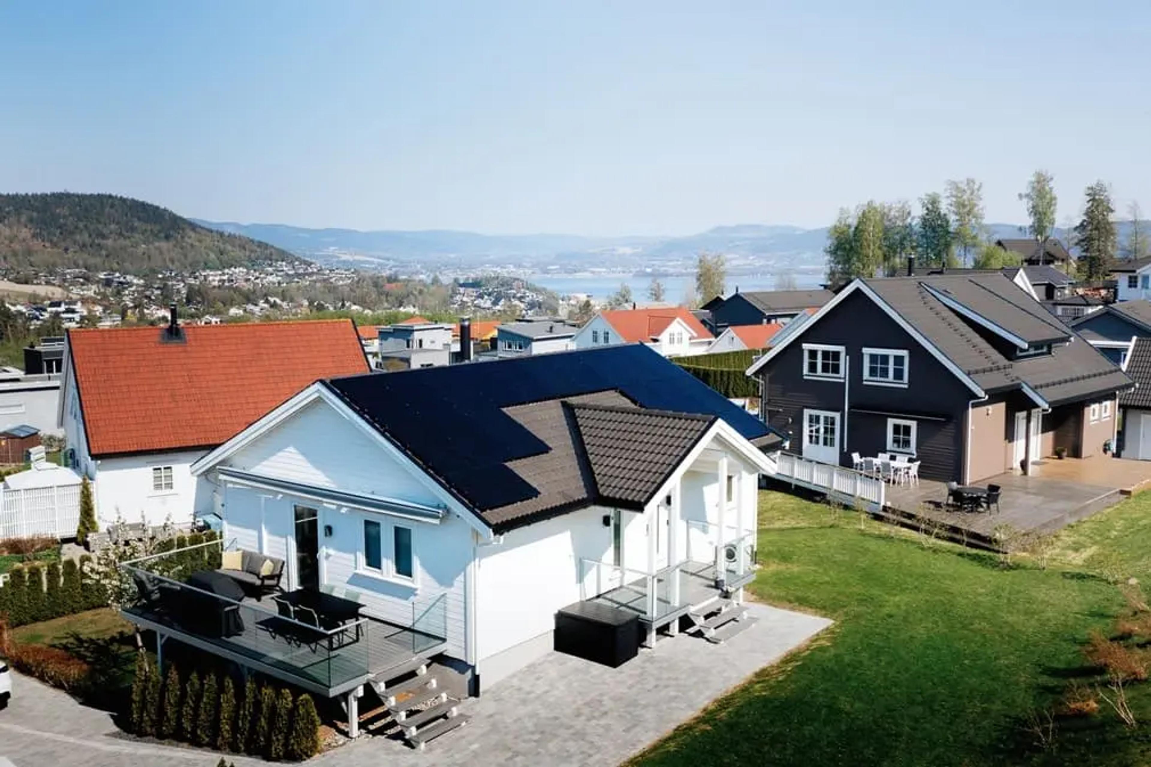 hvitt hus i nabolaget med solcellepaneler på taket