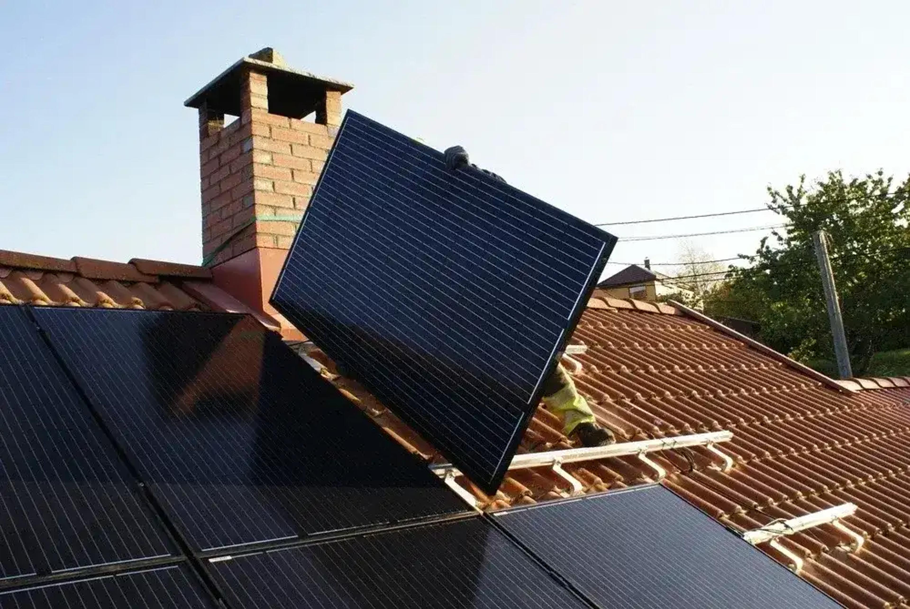 Dach mit Solarpanels und Installateur bei der Arbeit