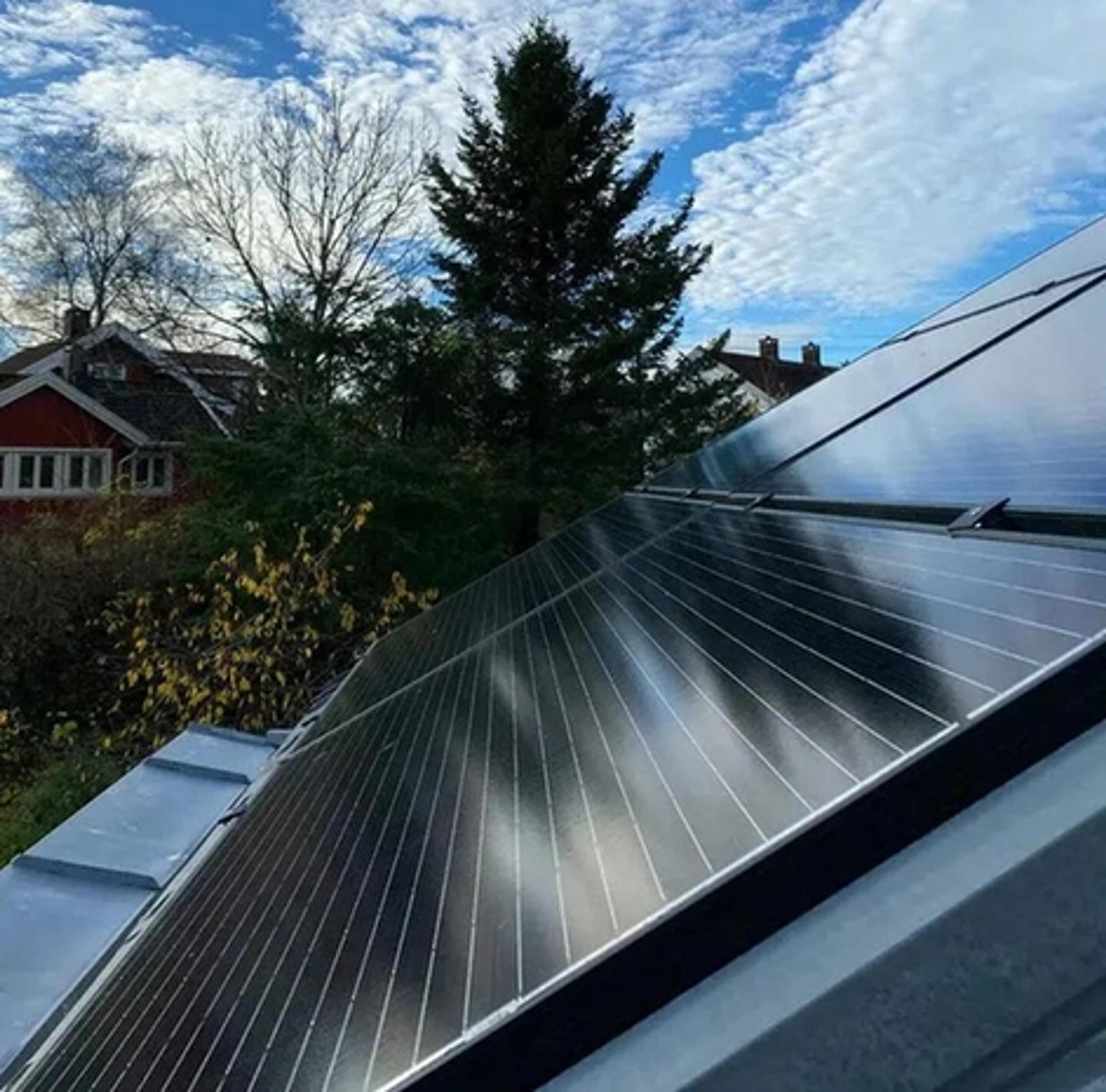 zonnepanelen op een dak met wolken op de achtergrond