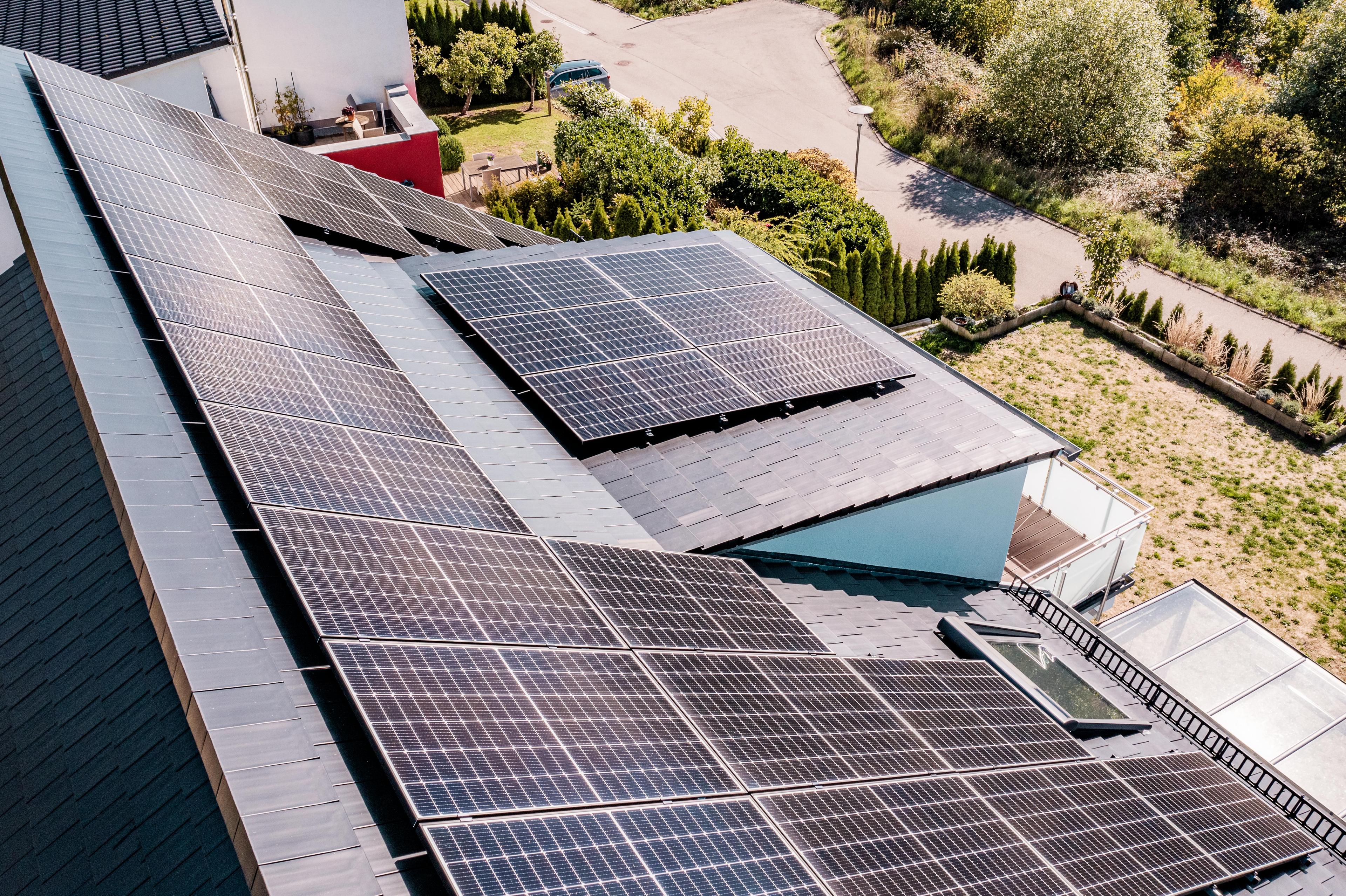 Gebäude mit Photovoltaikanlage mit schweizer Landschaft im Hintergrund