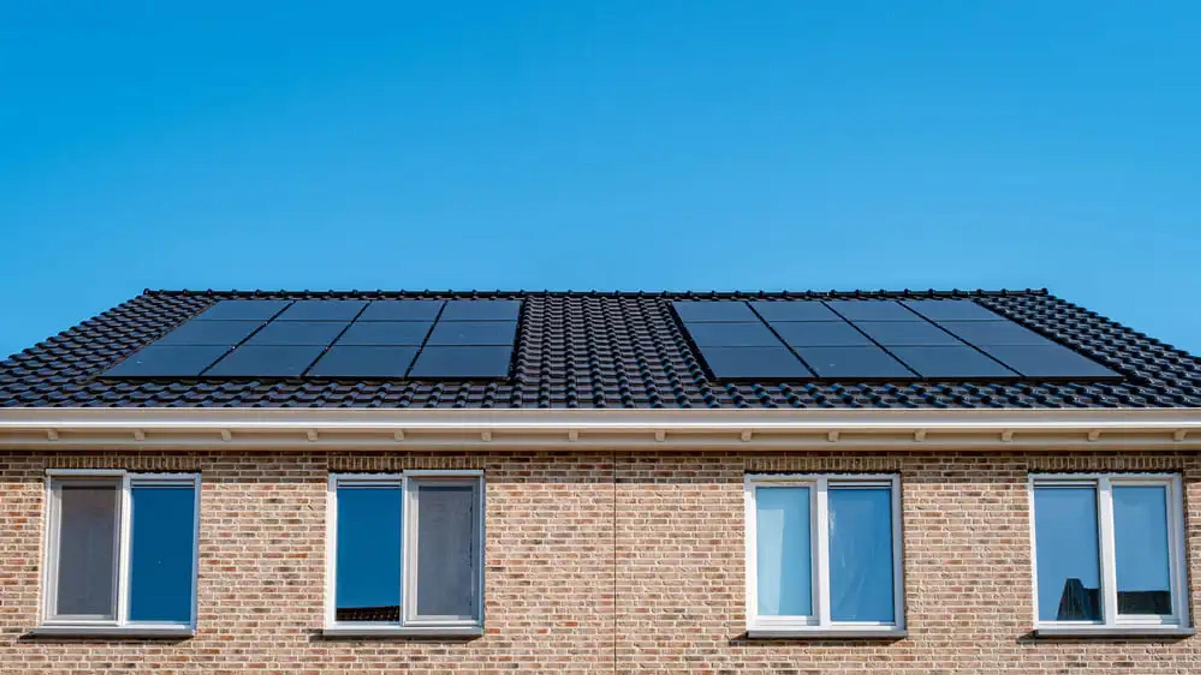 Solar panels installed on a house with a blue sky