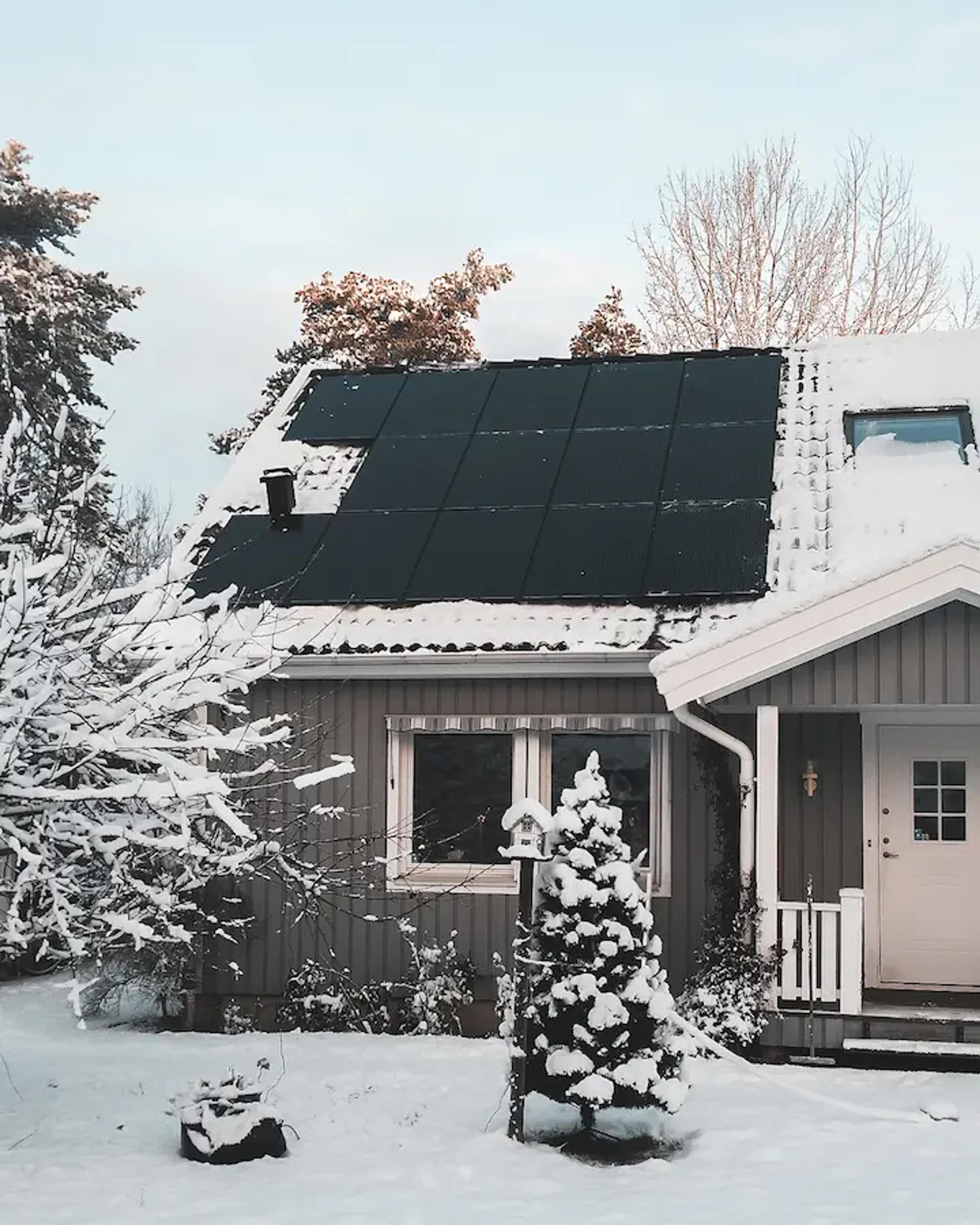 Full-Black-Module auf einem verschneiten Dach.