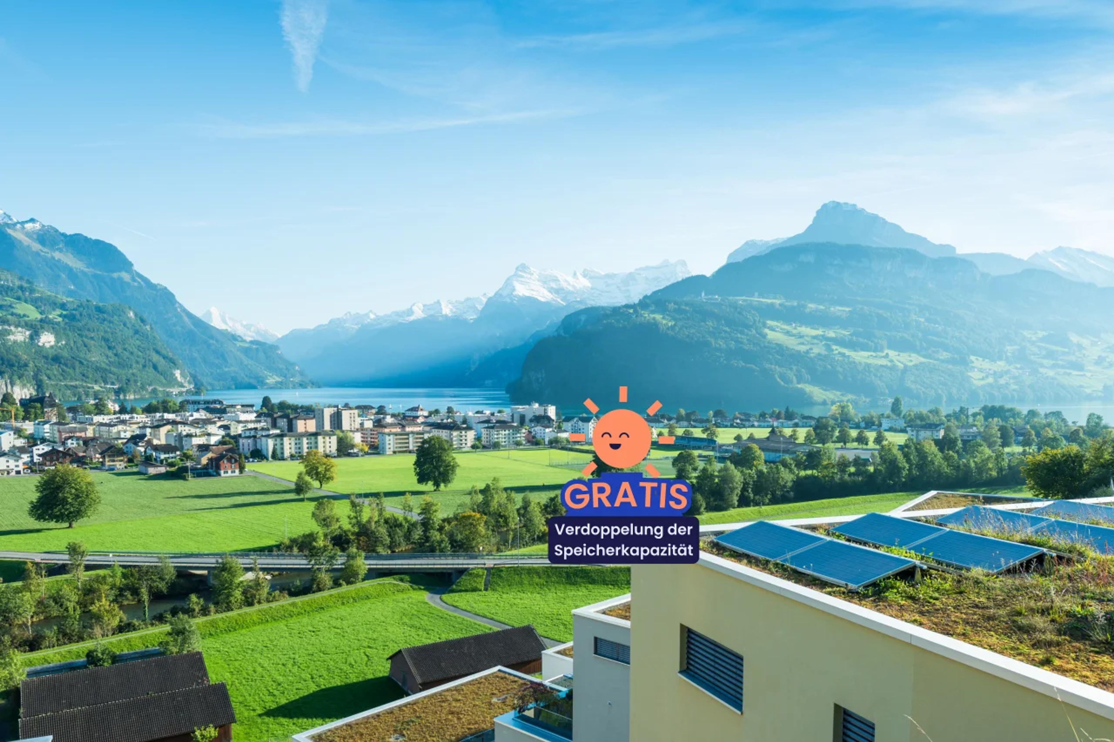 Gebäude mit Photovoltaikanlage mit schweizer Landschaft im Hintergrund  