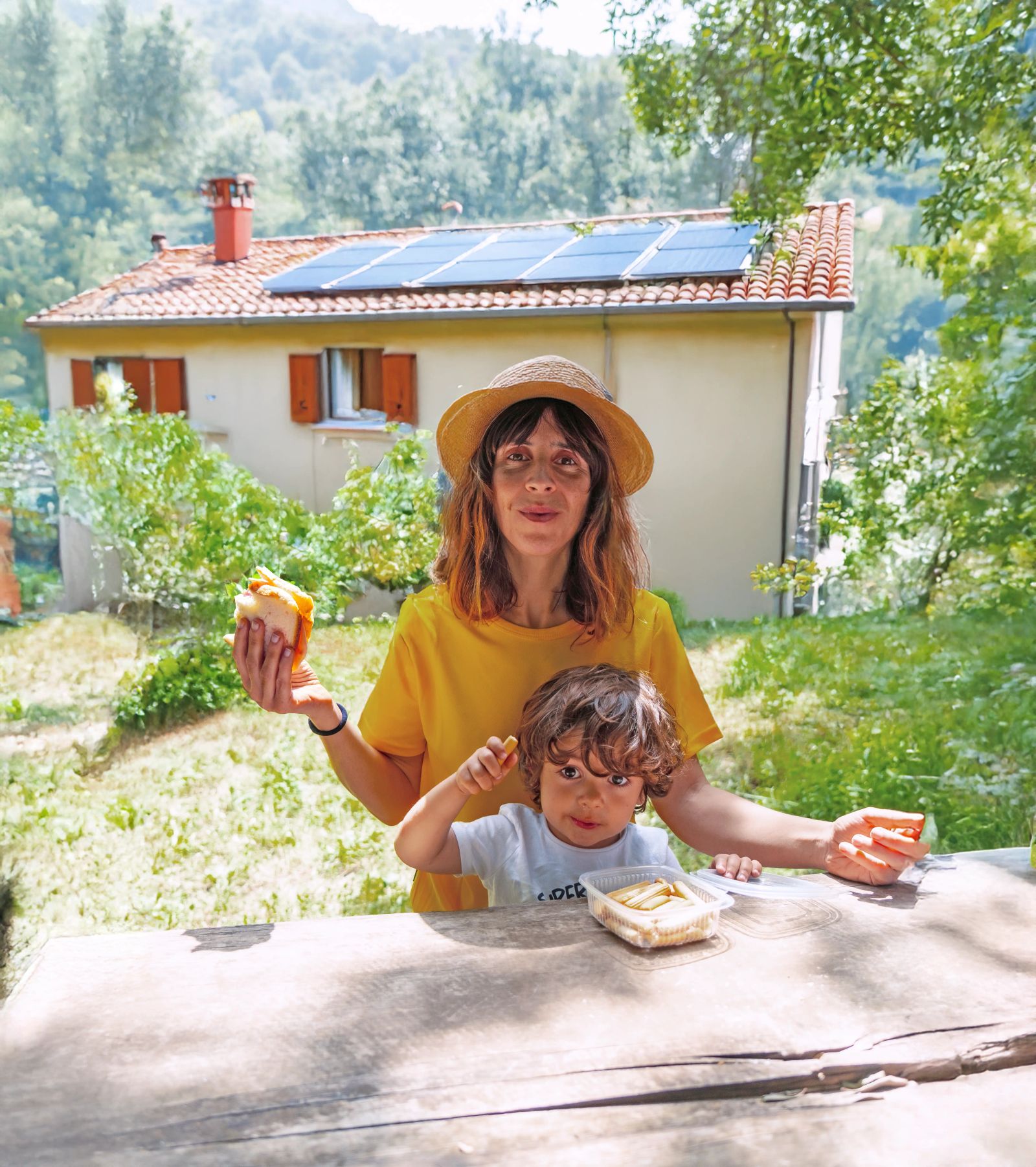 mulher com filho e paineis solares ao fundo