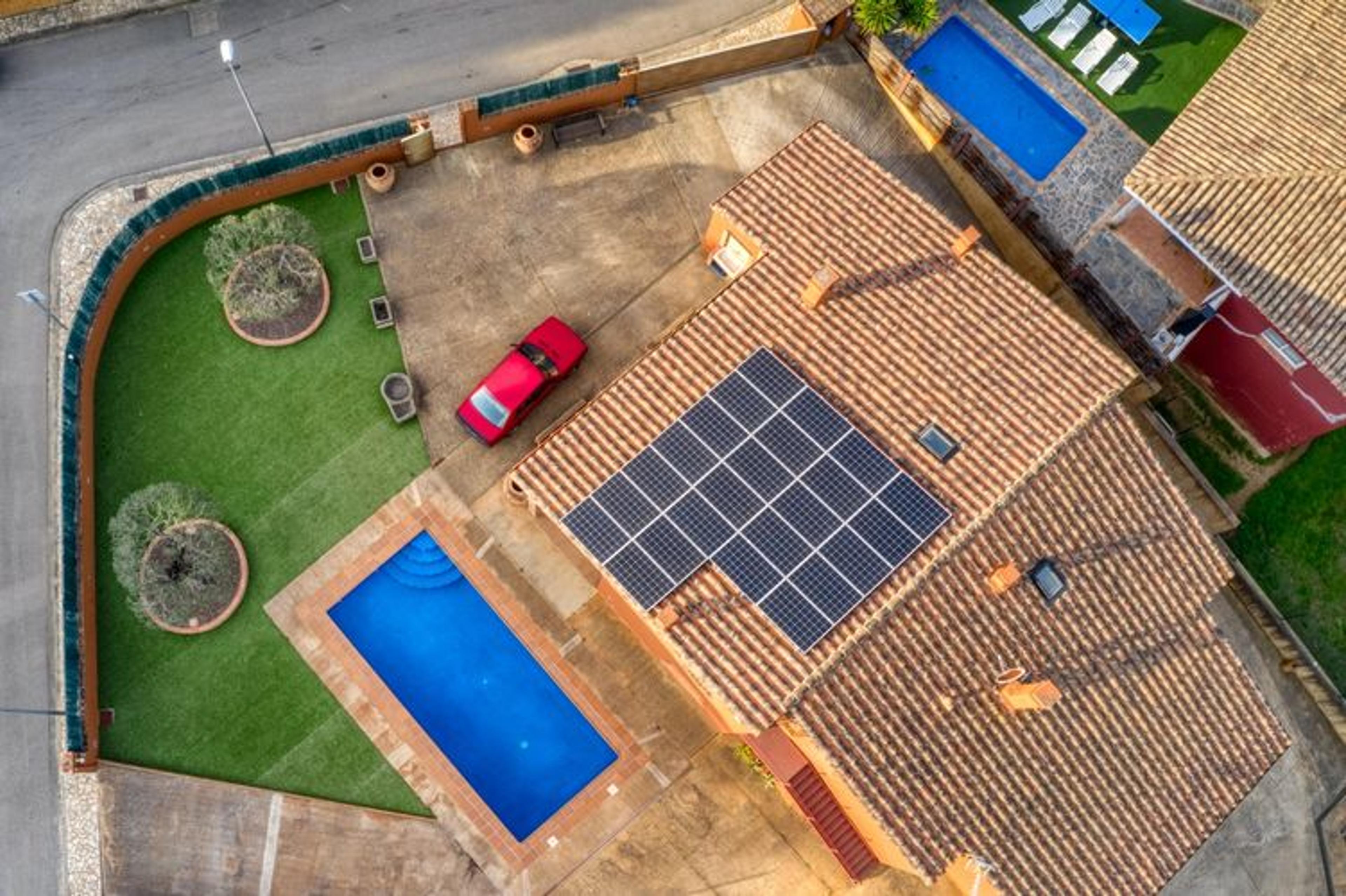 Instalación de paneles solares vista aérea en casa con piscina