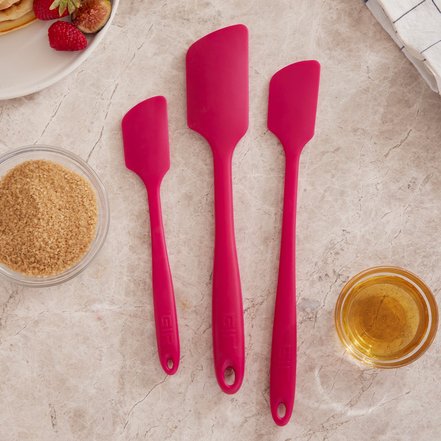Three spatulas in various sizes on a marble background.