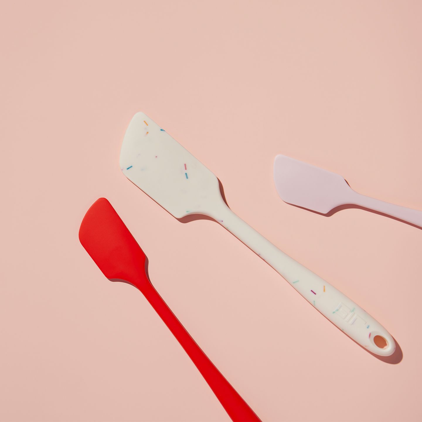 Variety of spatulas on a pink background