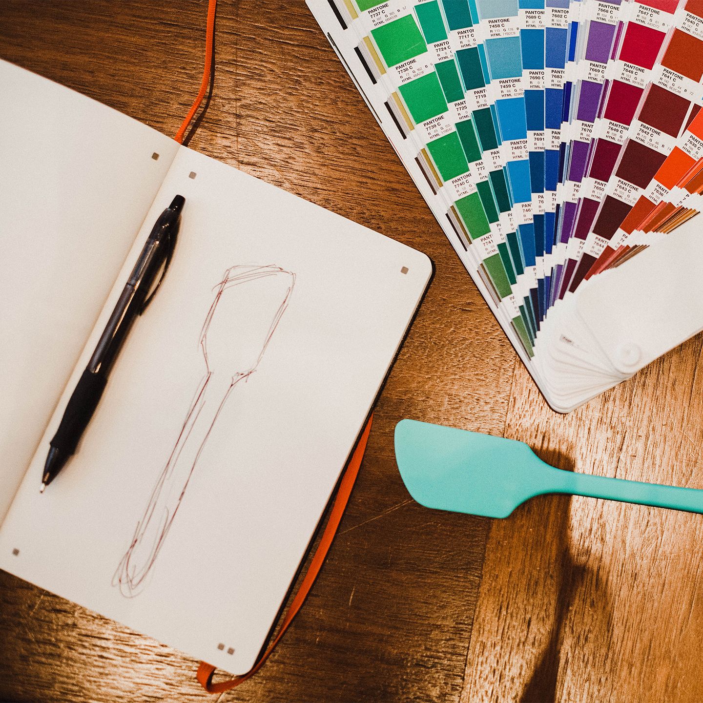 Sketch of a GIR Spatula and color swatches on a wooden table.
