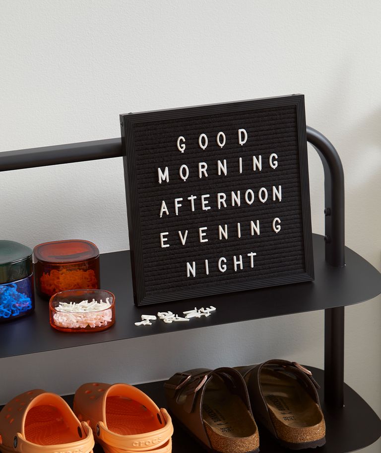 The Poet Letter Board on a black entryway rack.