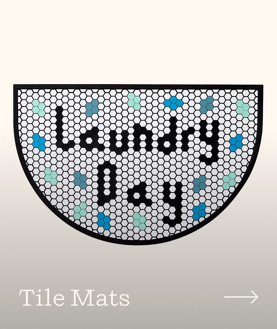 A half moon tile mat with a "laundry day" design on it.