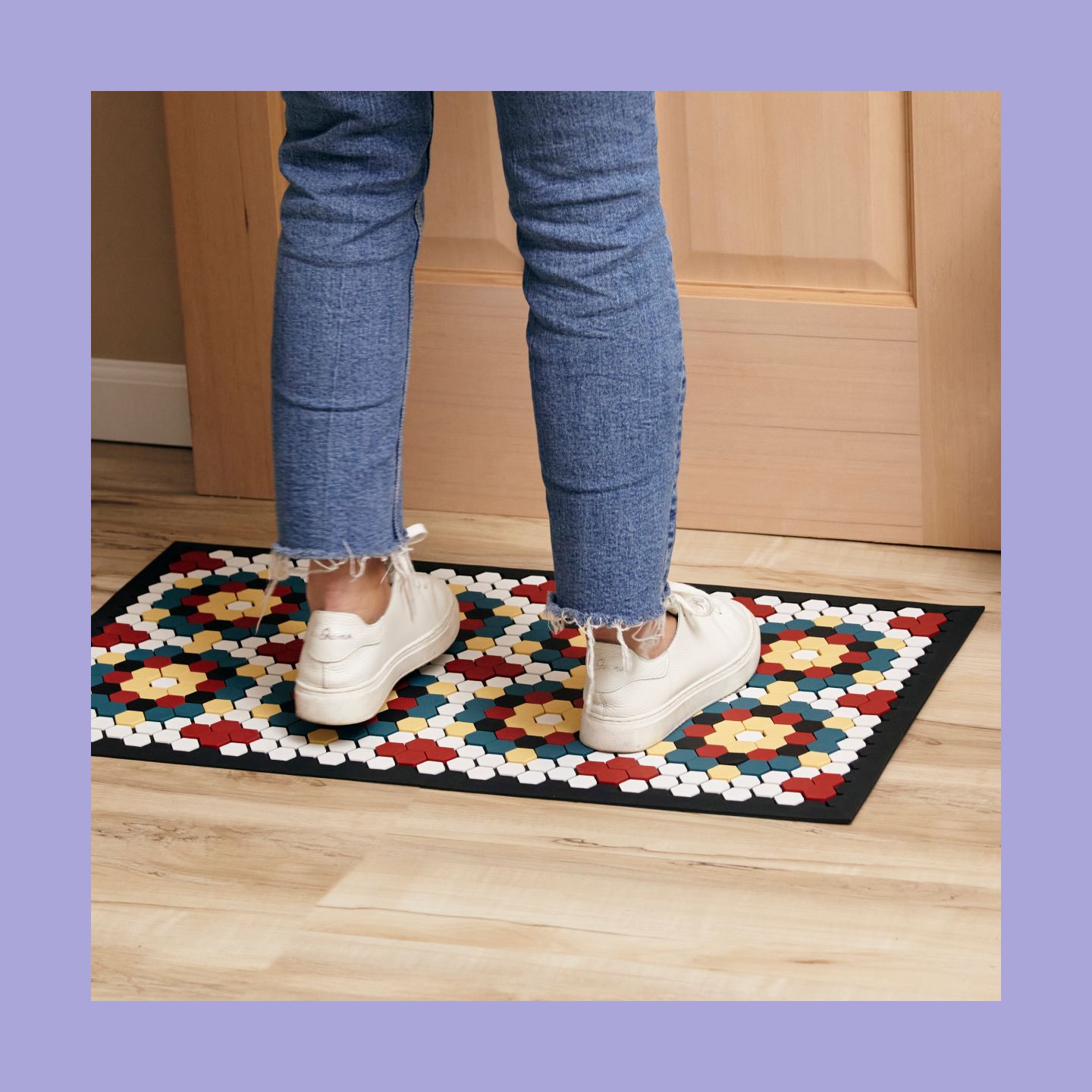A woman standing on top of a tile mat with a mosaic design.