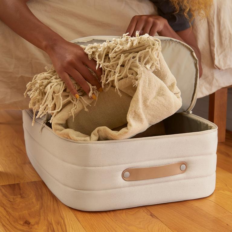 Someone opening a underbed storage to grab a blanket.