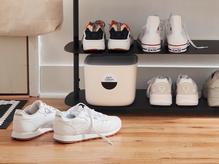 A shot of the bottom of a entry way rack with belongings.