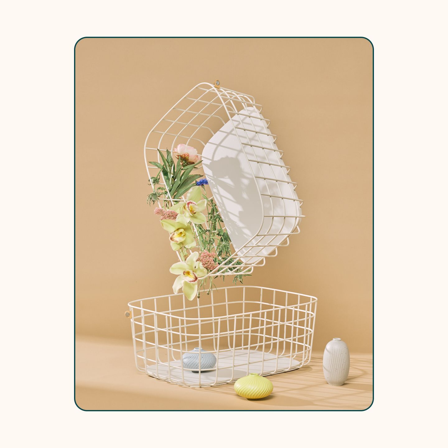 An image of the Open Spaces wire baskets in cream with flowers spilling out. 