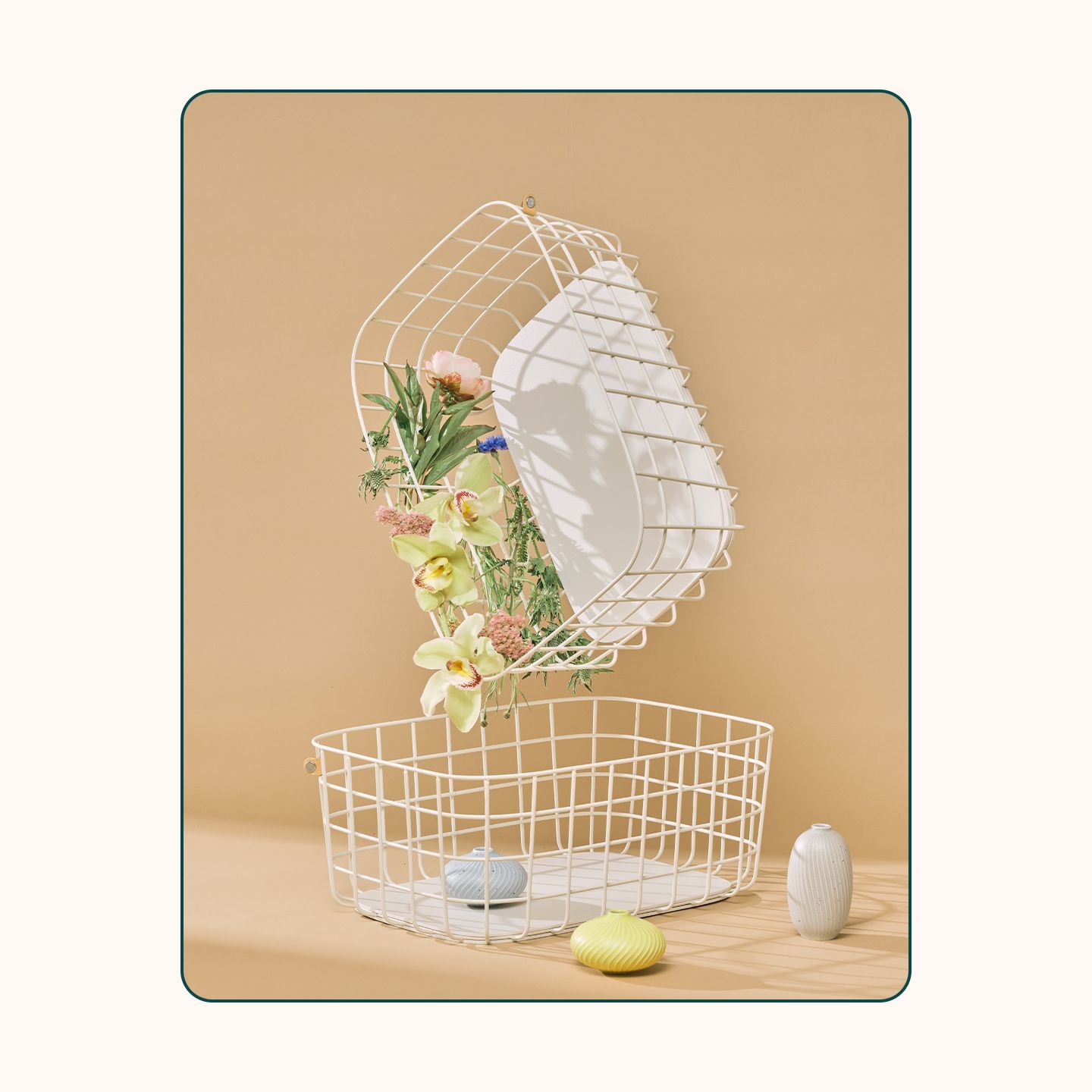 An image of the Open Spaces wire baskets in cream with flowers spilling out.