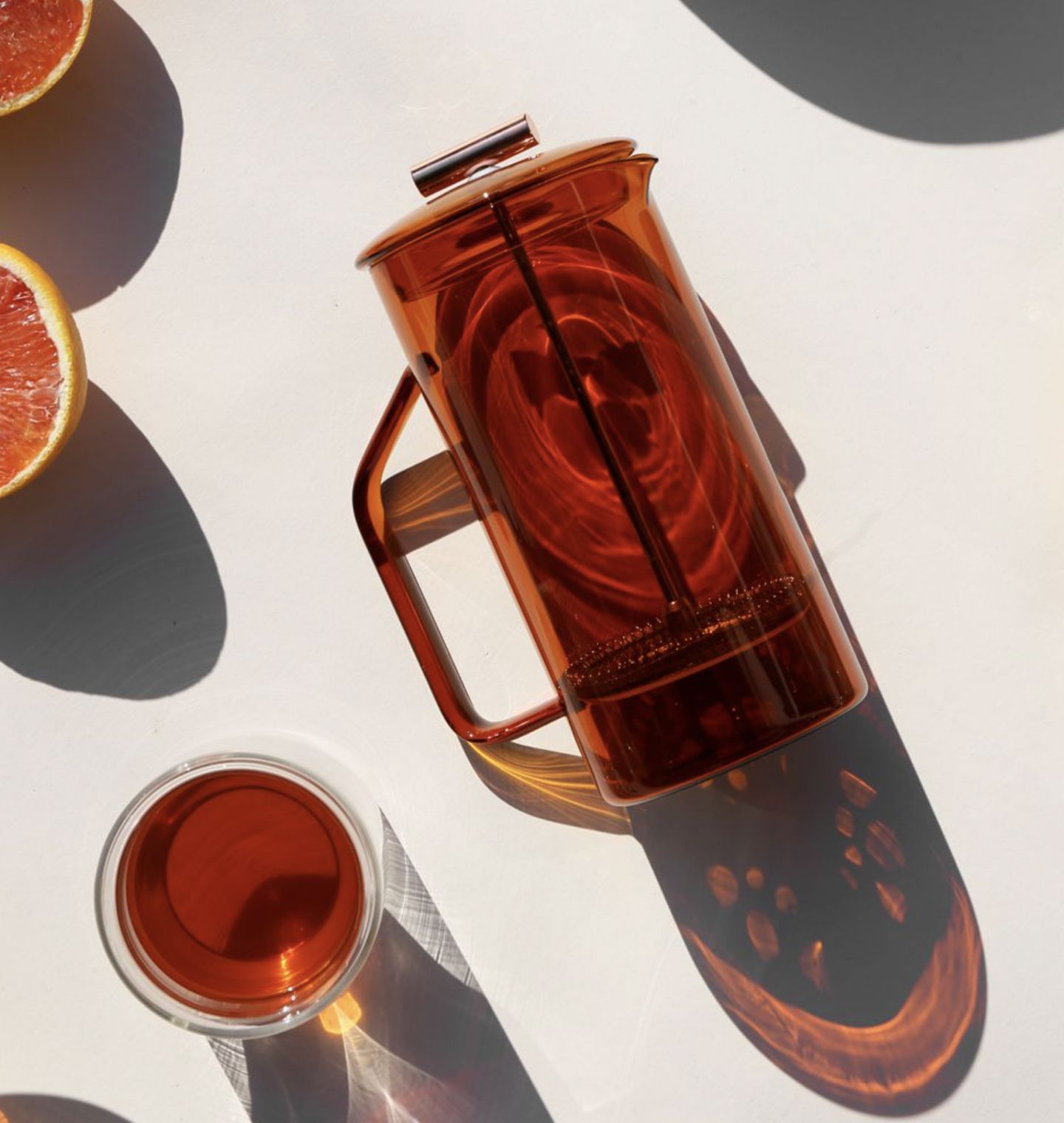 Amber french press on a cream background.