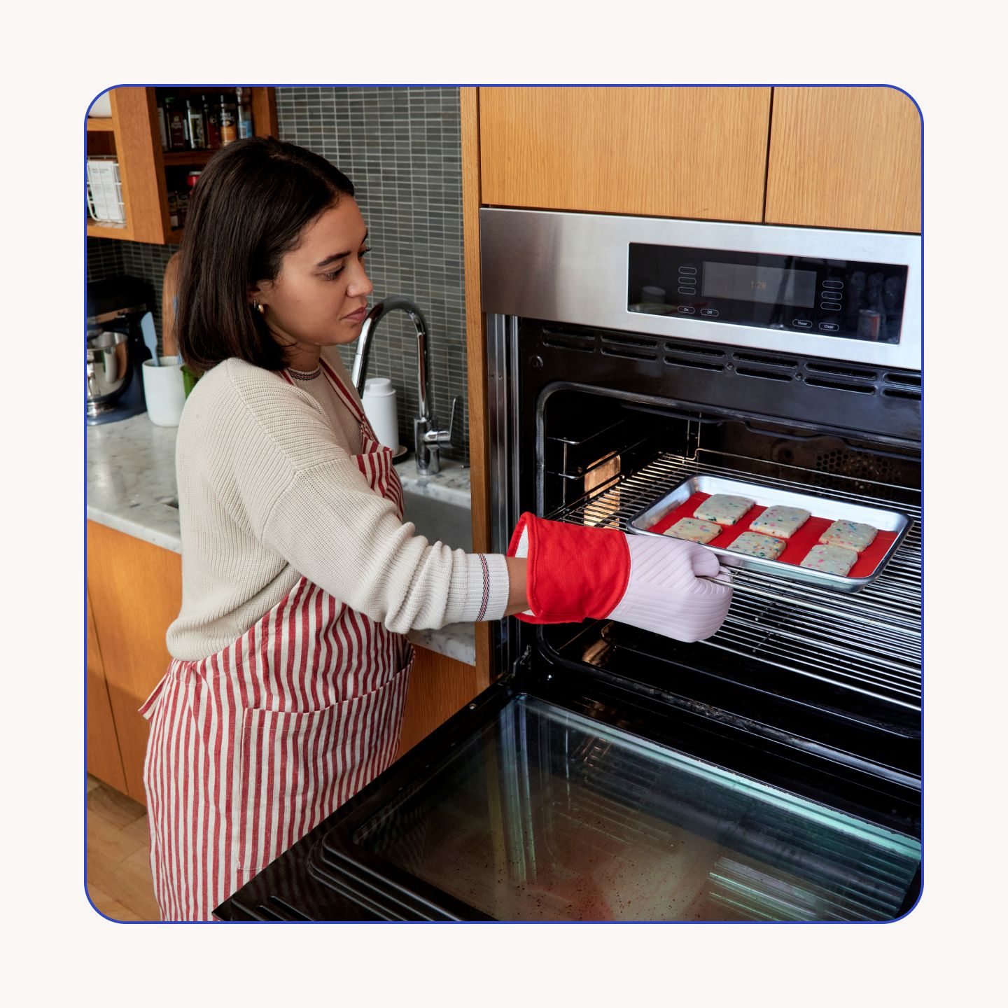 Oven mitts in use in a kitchen setting.