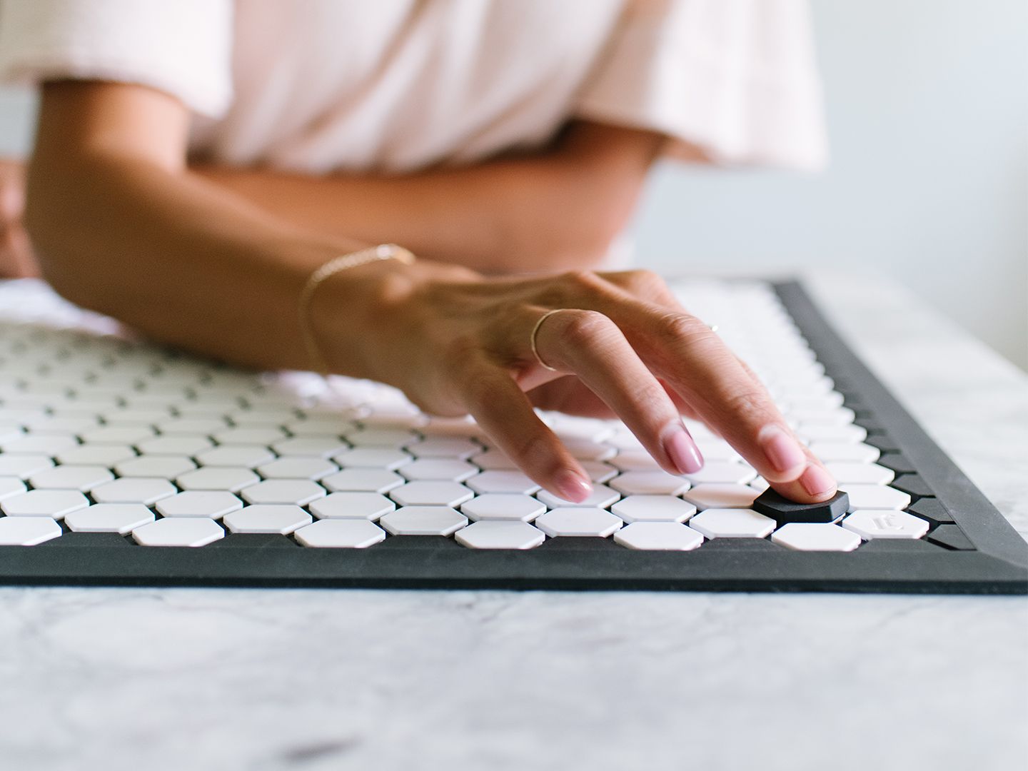 A close up of a hand placing a tile on a tile mat