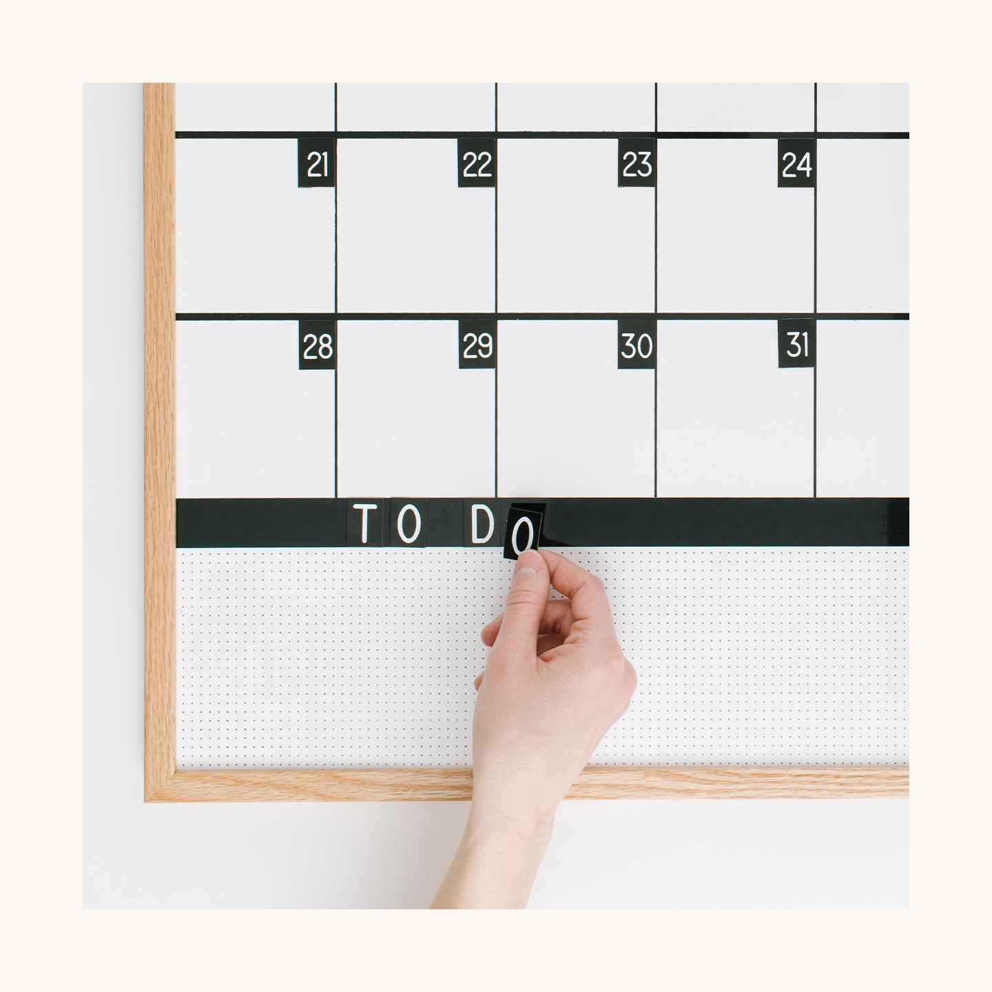 A hand putting on letters on a block calendar.