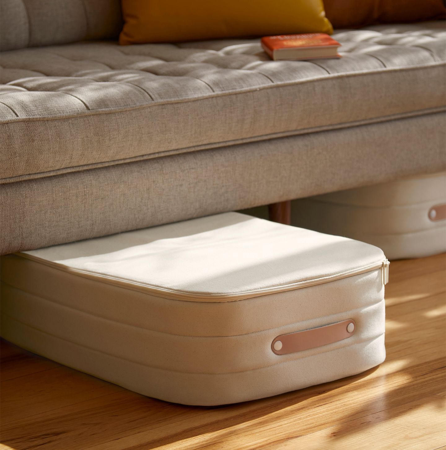 The new cream Underbed Storage coming out from underneath a couch.