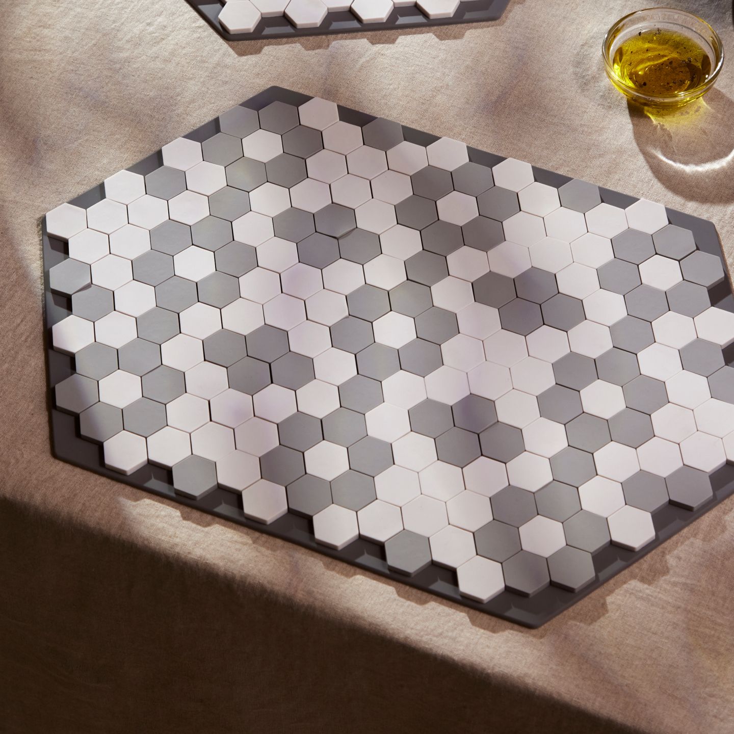 A placemat with a floral tile design on a table.