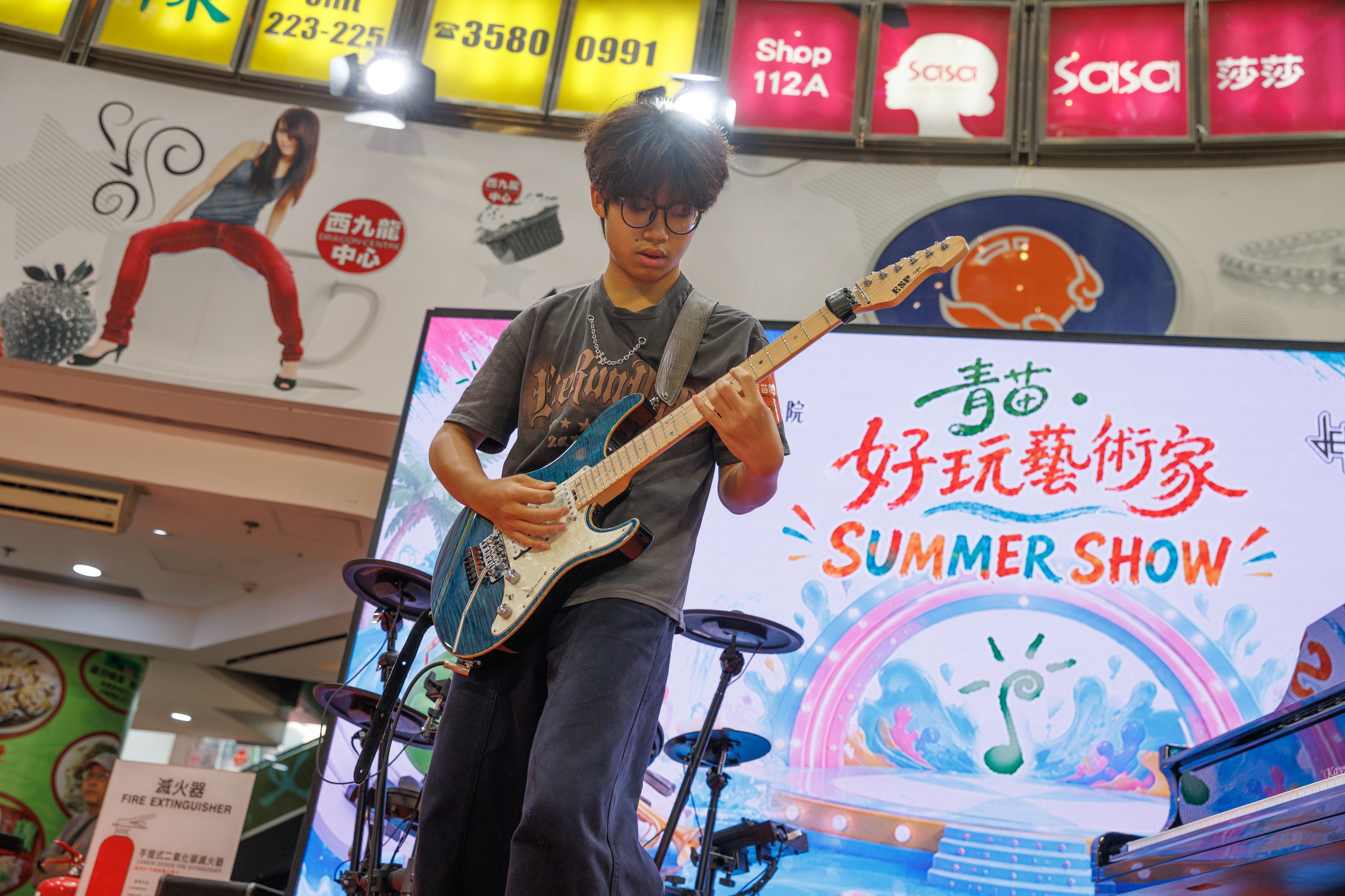 青苗琴行學員在好玩藝術家 Summer Show 舞台上專注演奏電子結他