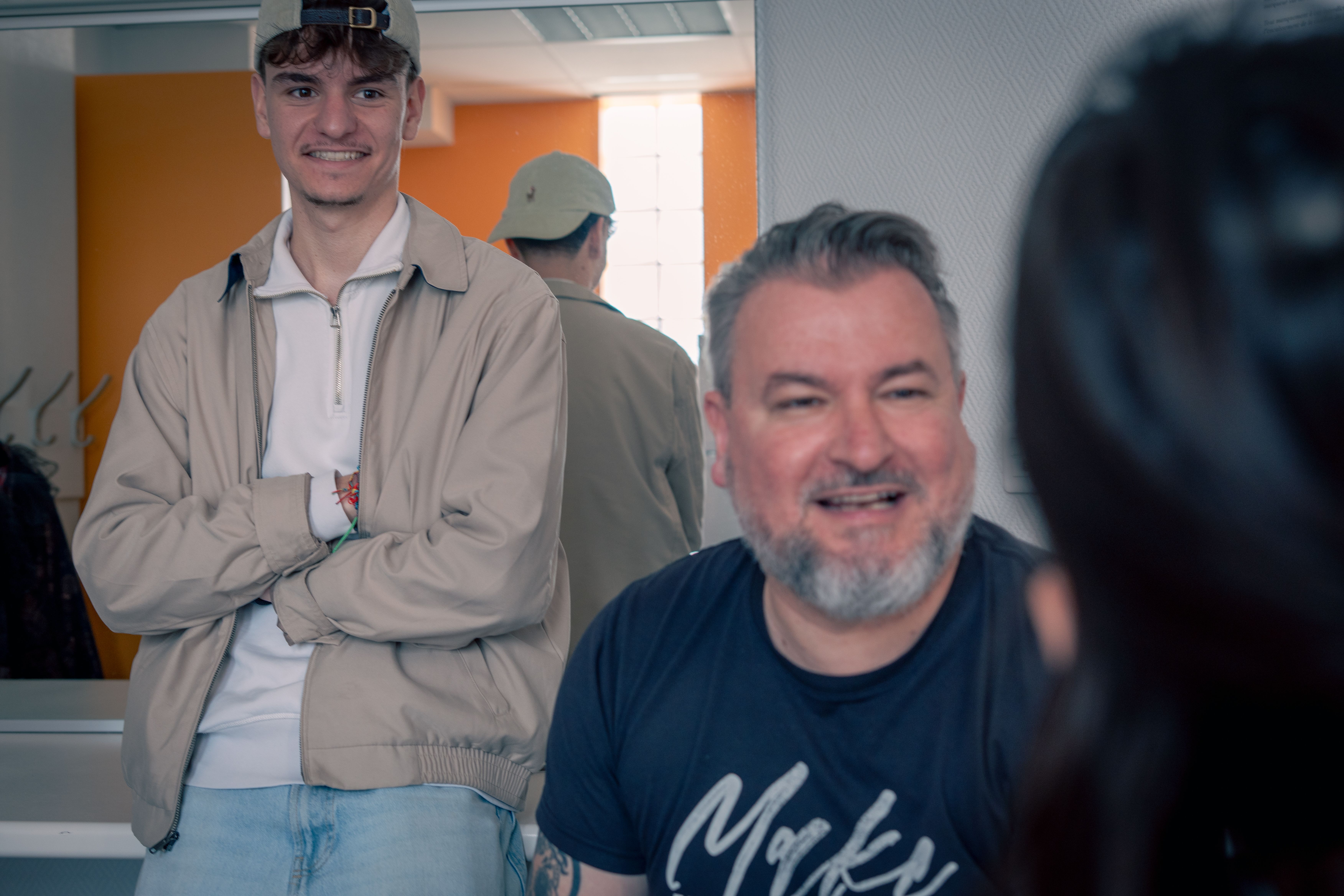Deux comédiens sourient en coulisses, avant d'entrer en scène