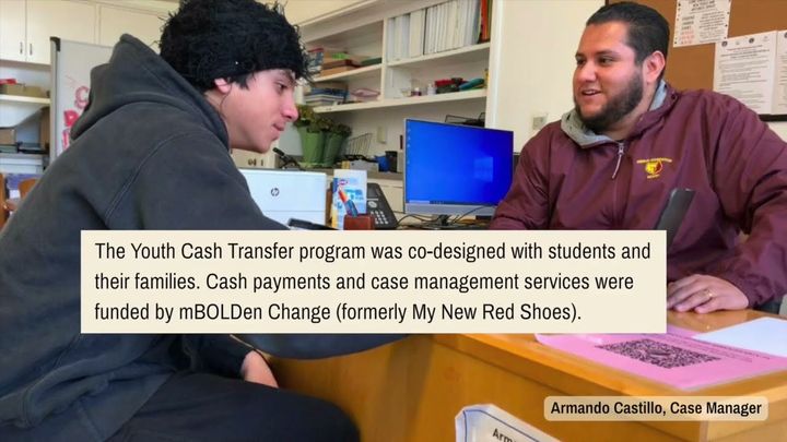 Case manager Armando Castillo meets with a student at his desk