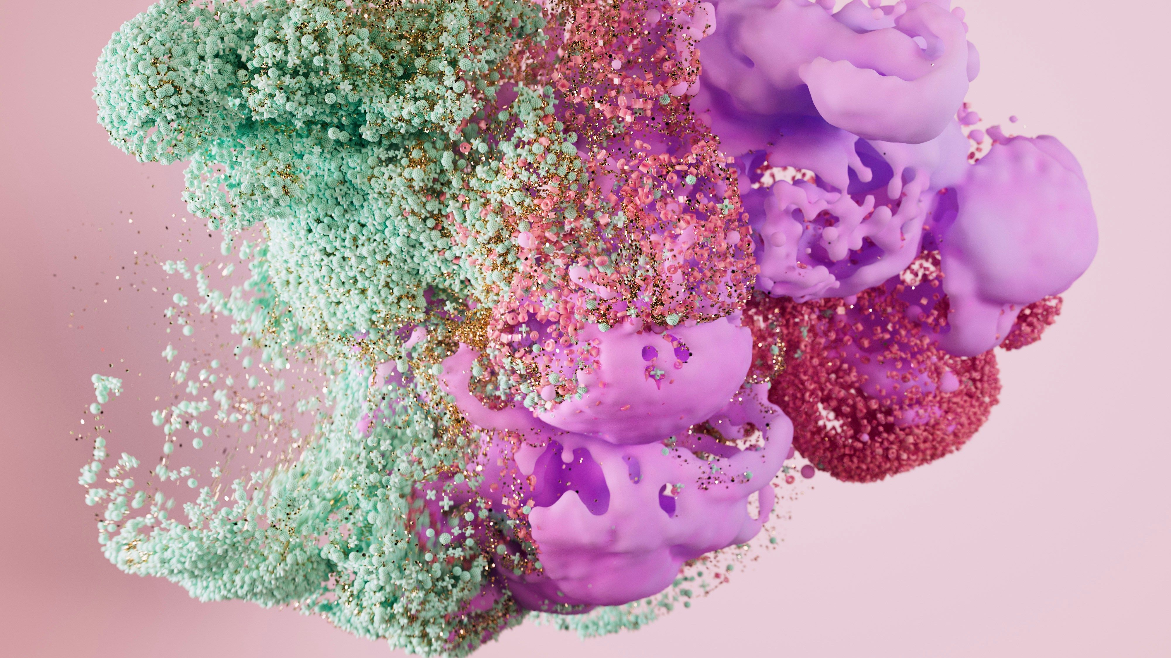 A green and purple abstract shape dissolving into small particles on a pink background.