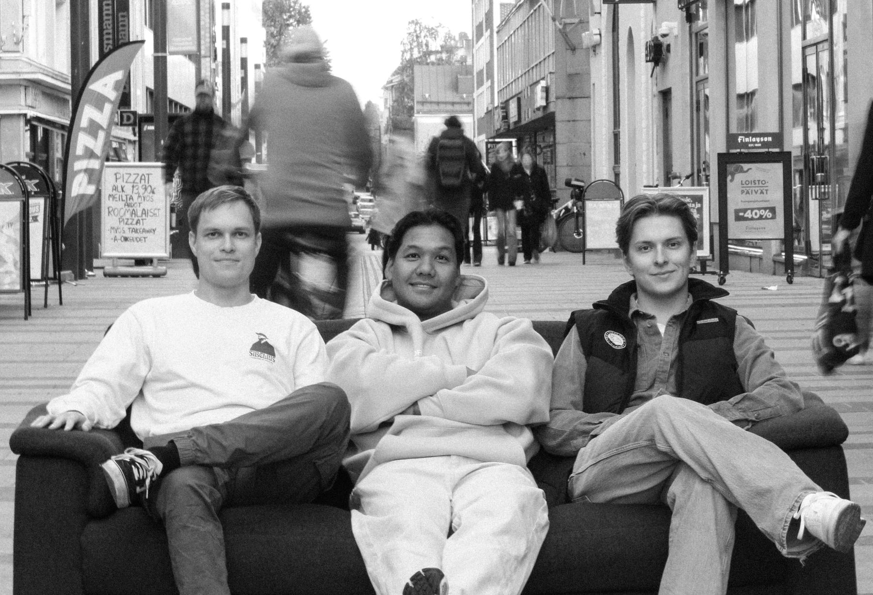 The photo shows Boggo's team sitting on the couch, with people moving around in the background.