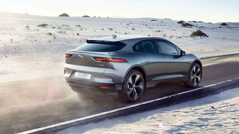A photo of a Jaguar I Pace car driving through a desert as part of electric vehicle training