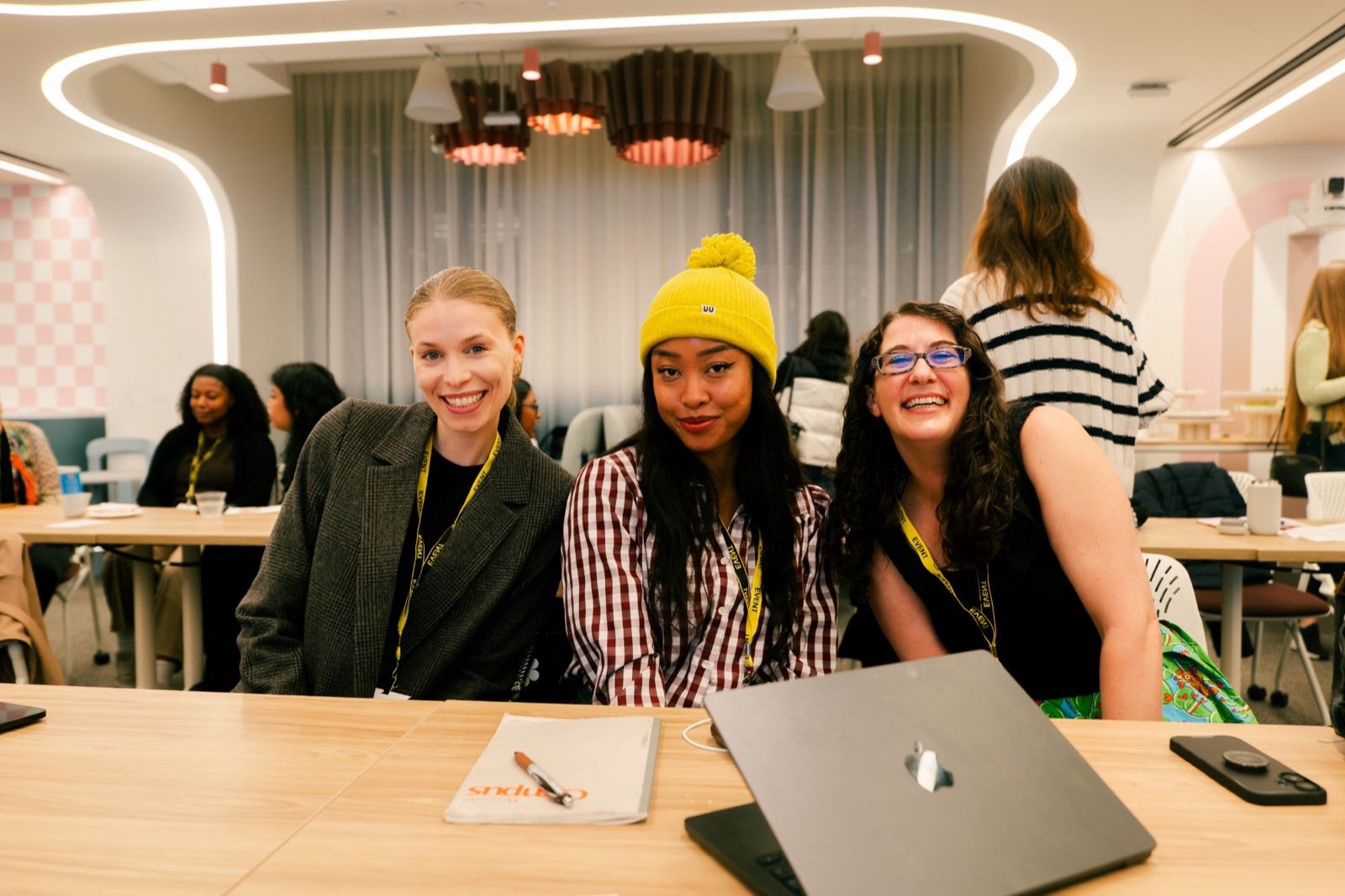 Three attendees smiling at a table at the AI Skills Share