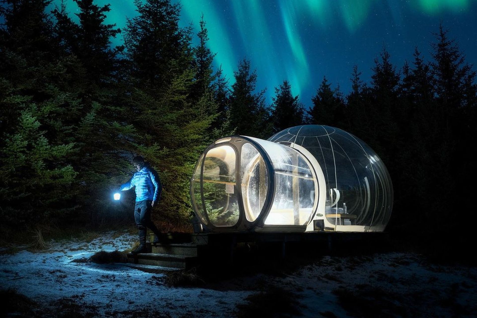 A transparent bubble tent, known as the 5 Million Star Hotel, set in the serene Icelandic wilderness under a star-studded sky.