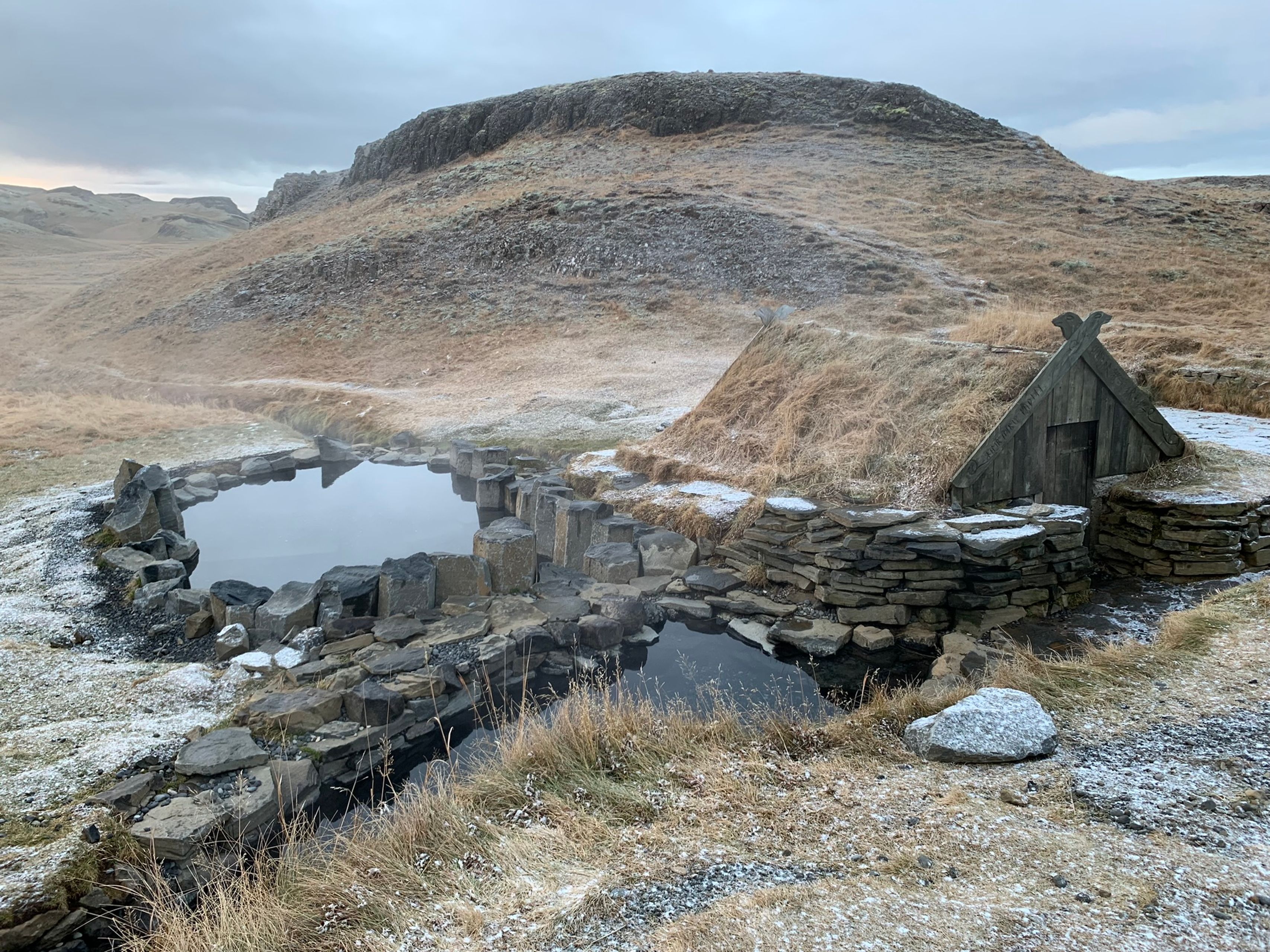 A small hot spring in Iceland with snow all around it