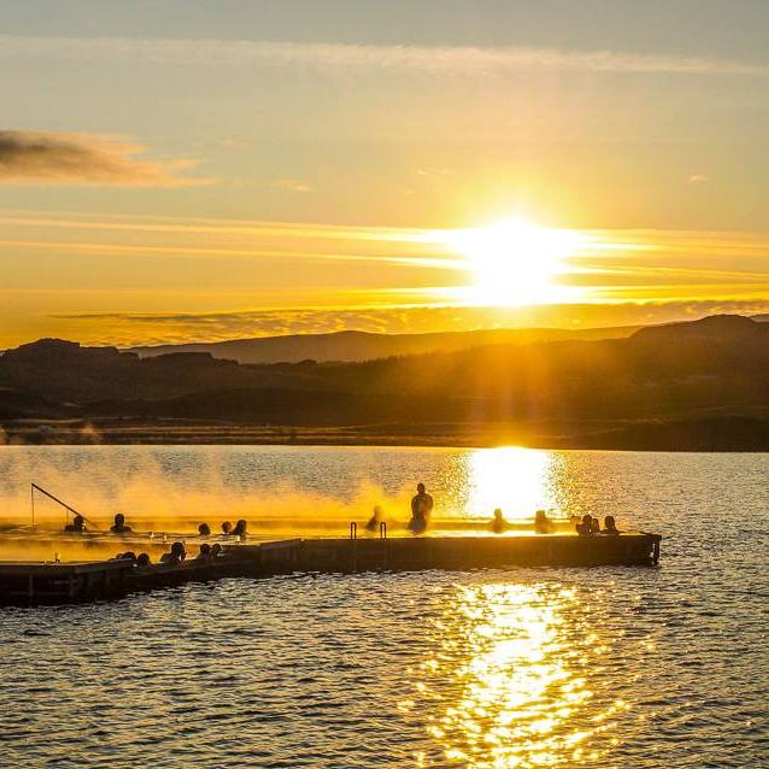 Group of people at Vök Baths during sunset