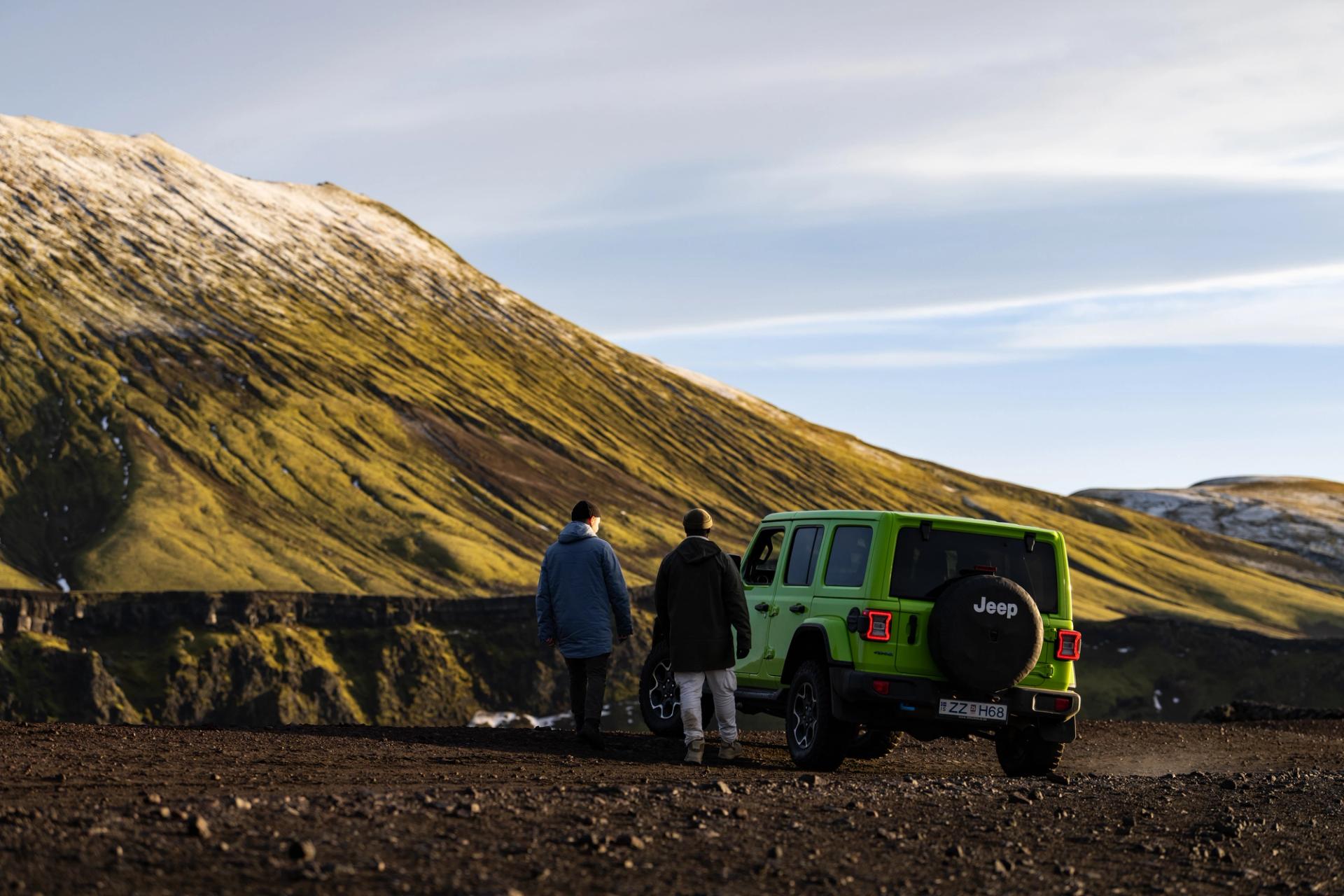 2 friends relaxing together and watching the landscape of Iceland near a Jeep rental car