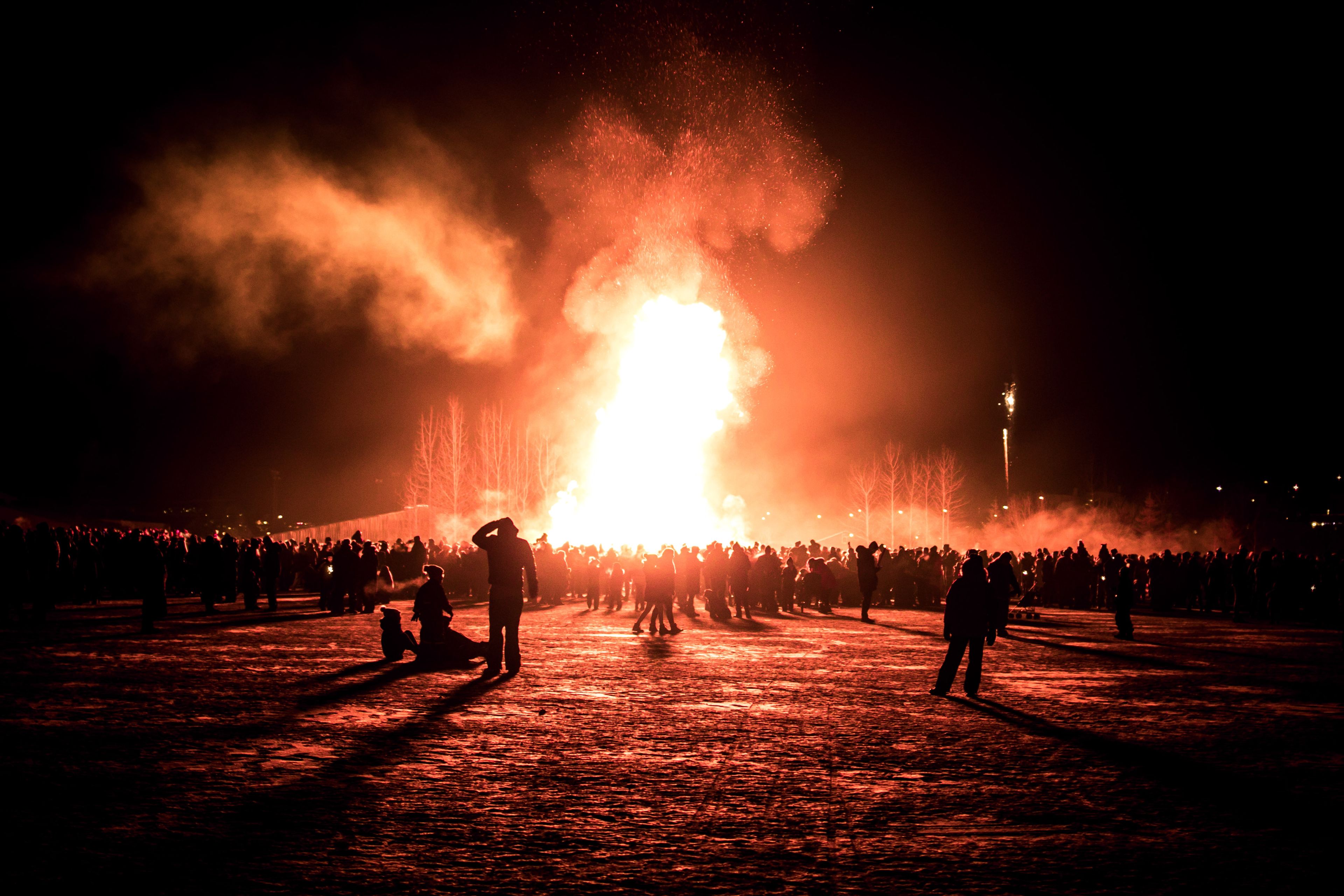 People celebrating New Year's Eve in Iceland with new year's fireworks and bonfires