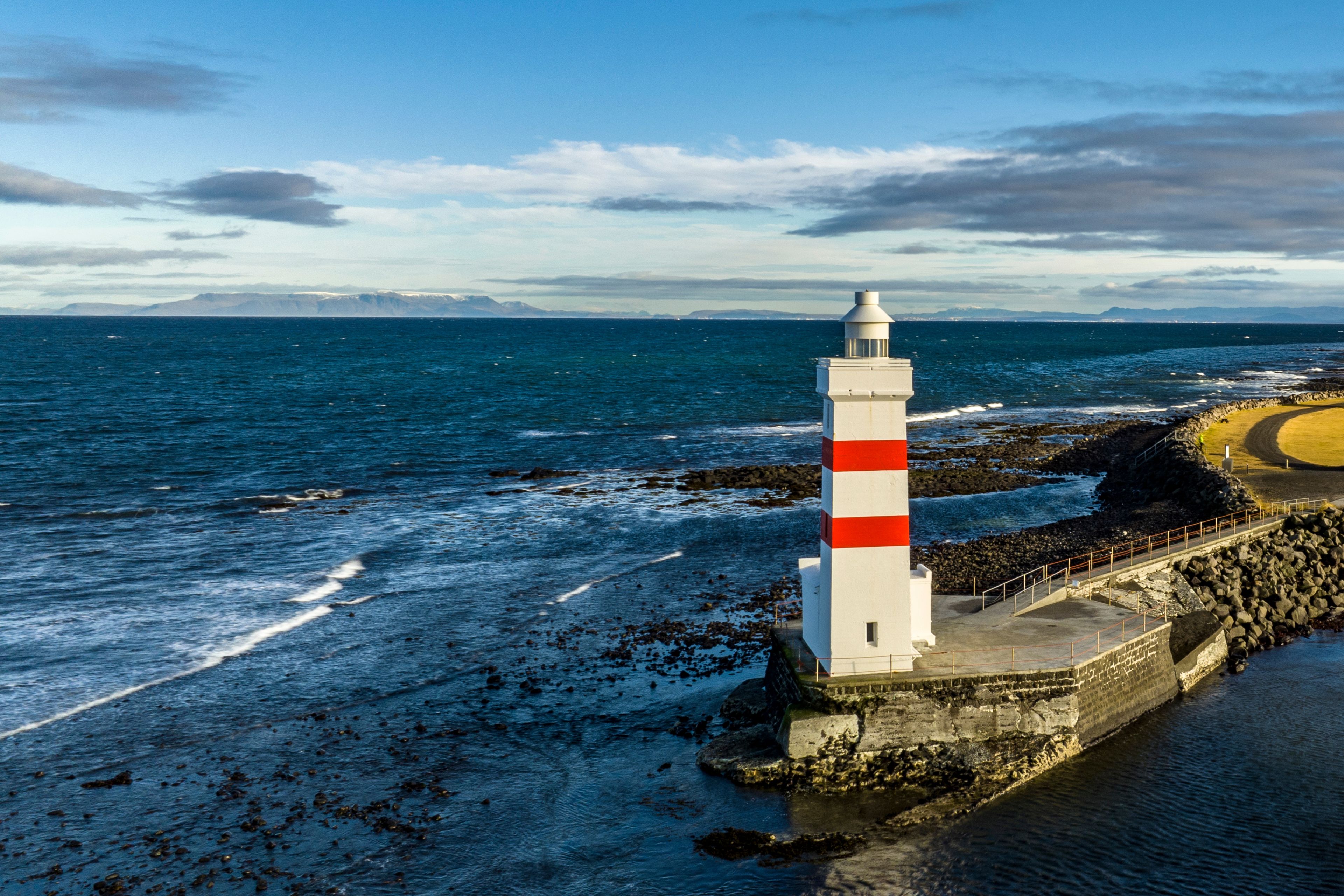 Panoramic view on Garður Old Lighthouse, surrounded by the ocean
