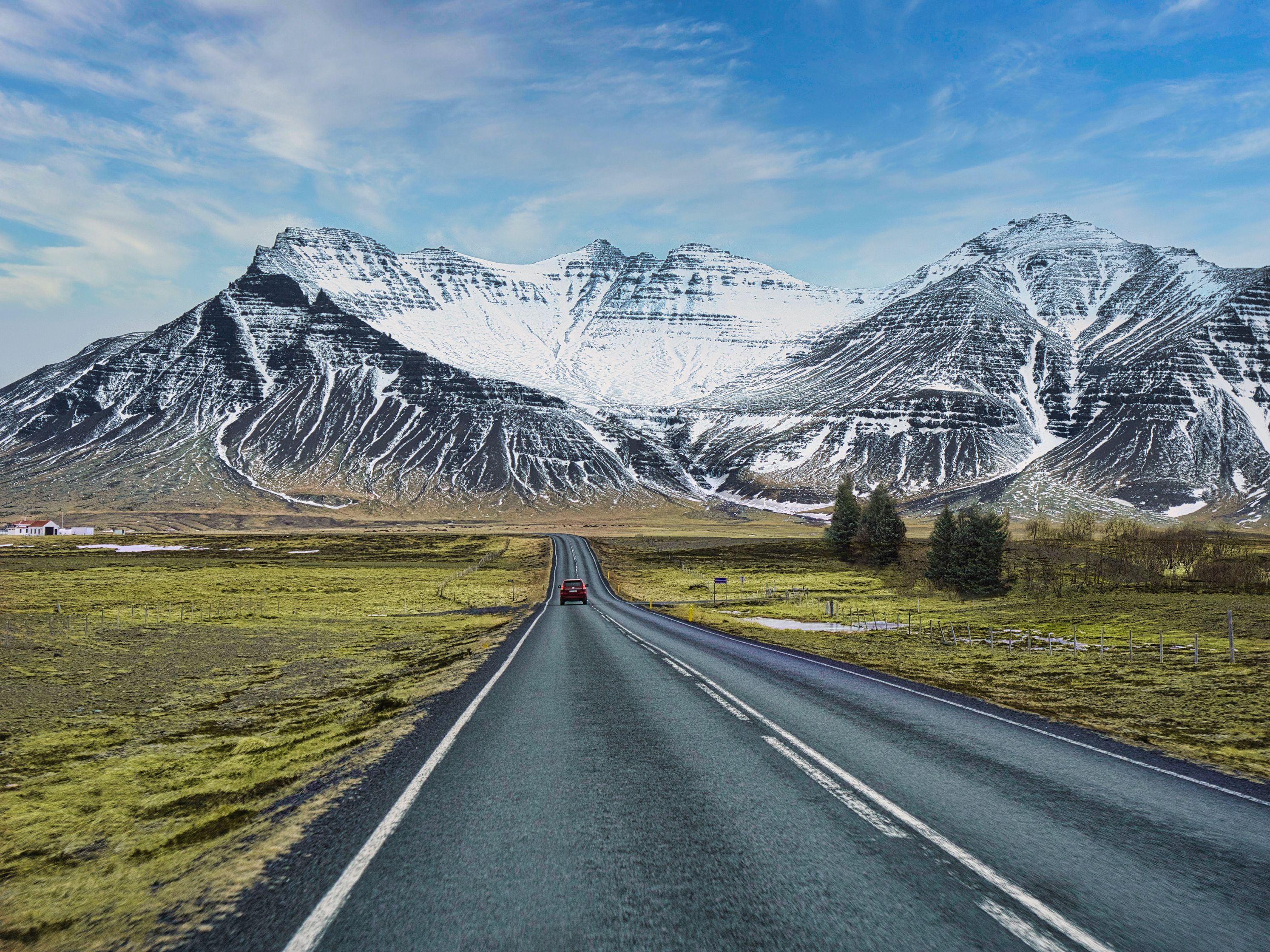 Car driving towards snowy mountains in Iceland