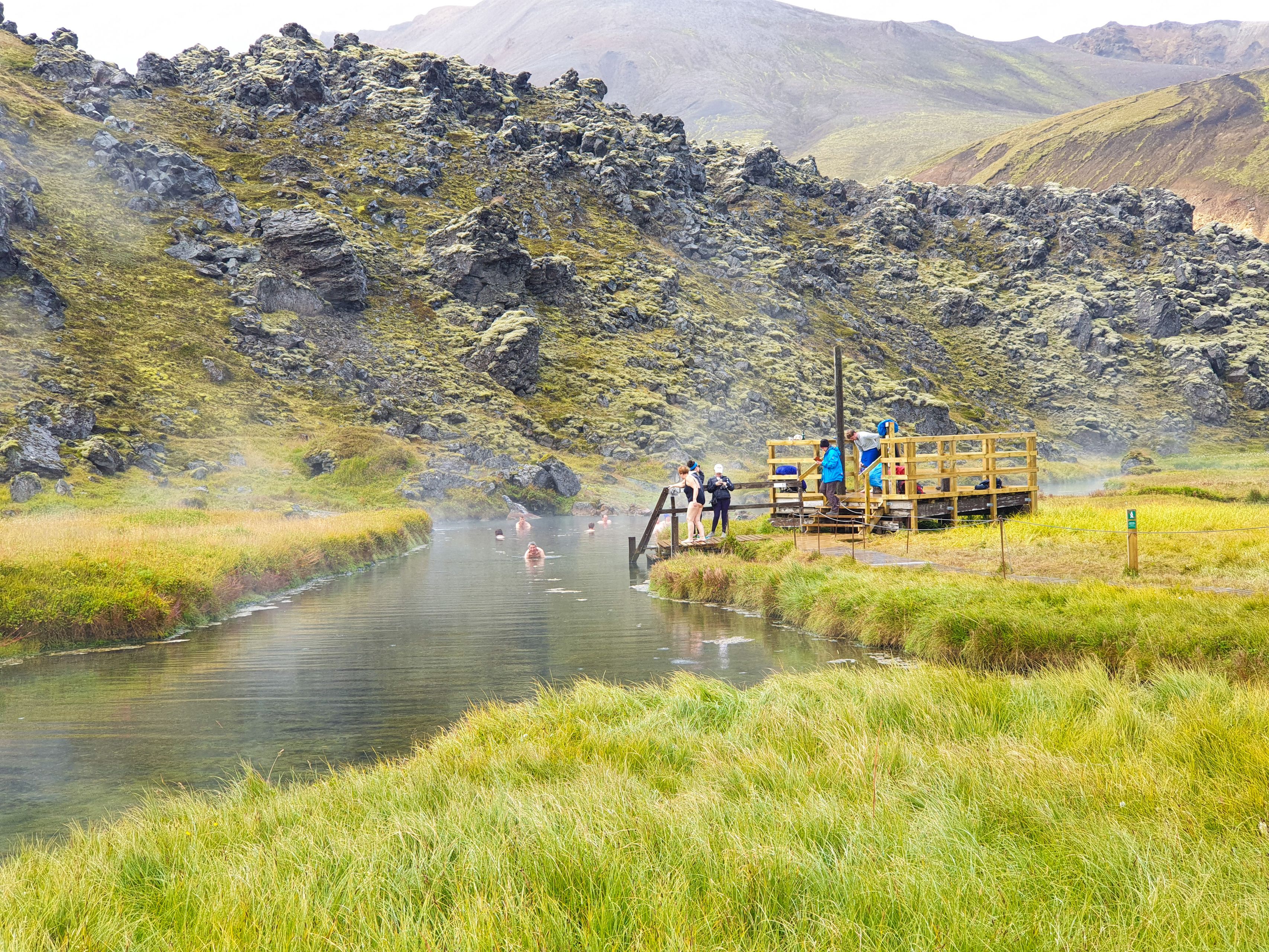 People bathing in the hot springs of Landmannalaugarhot, a beautiful Icelandic landscape 