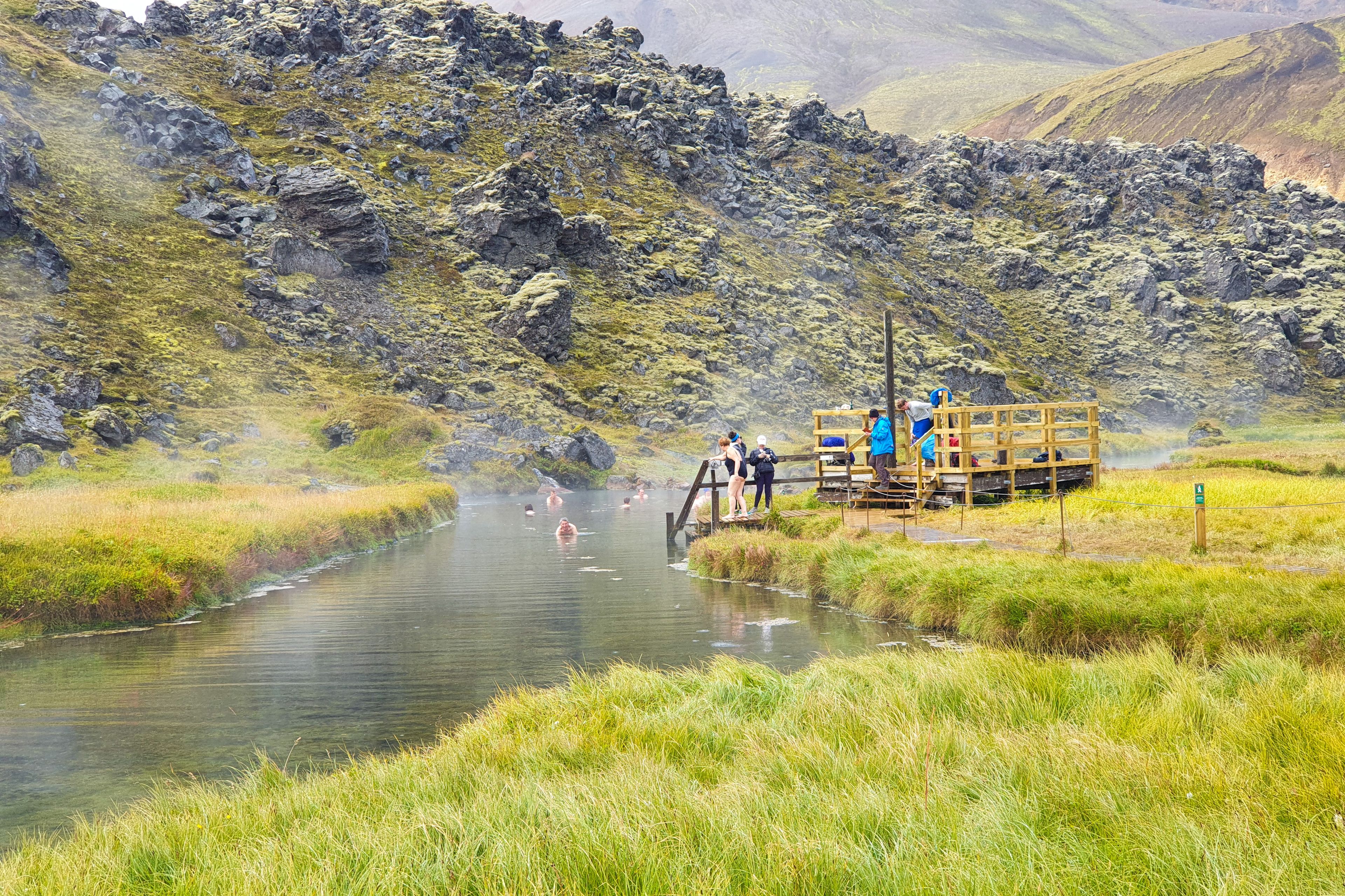 People bathing in the hot springs of Landmannalaugarhot, a beautiful Icelandic landscape 