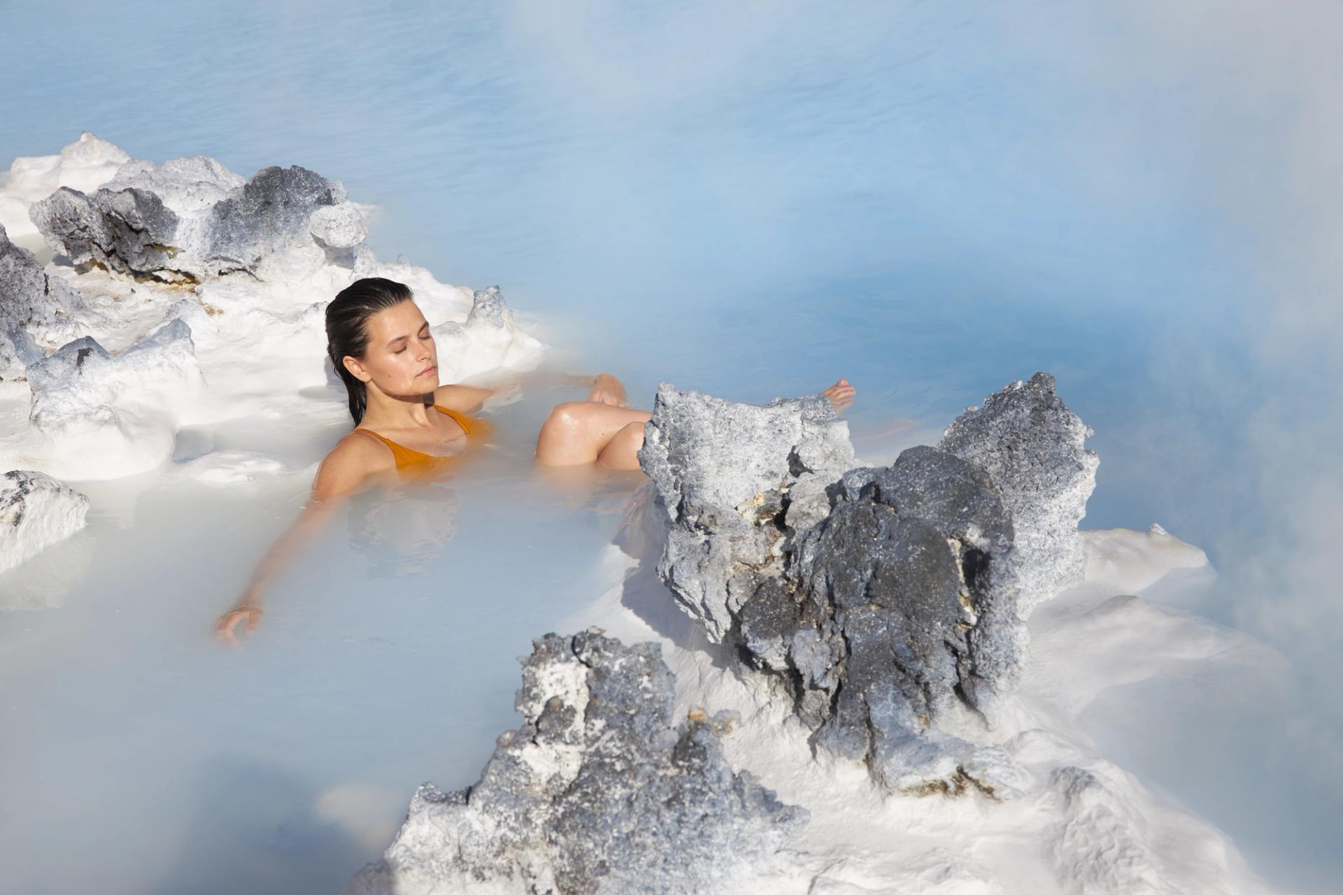 Woman relaxing in blue lagoon hot spring in iceland