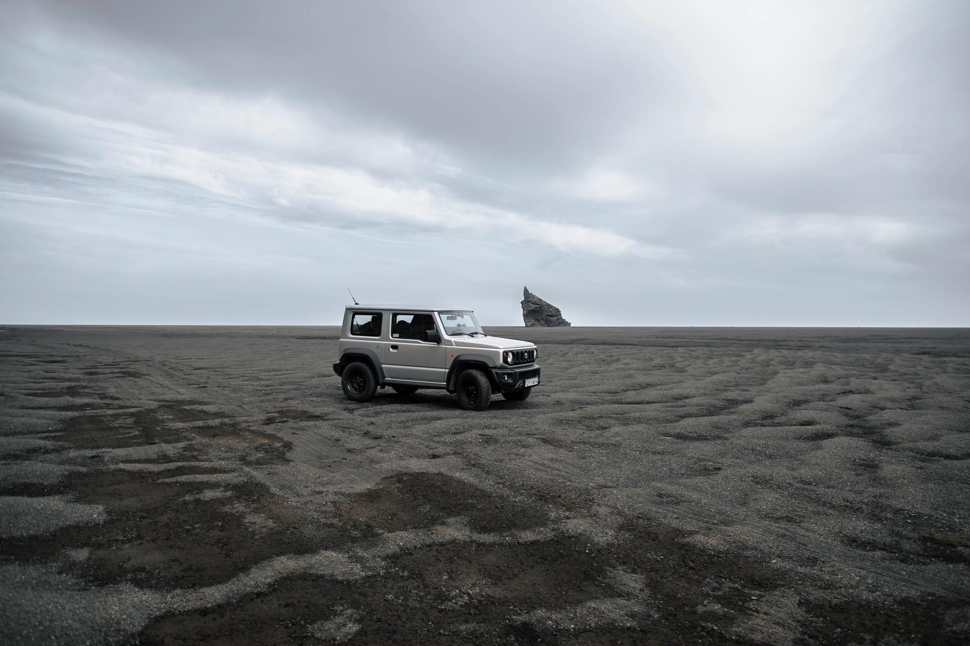 4x4 rental car Suzuki Jimny parked on a black sand beach in Iceland