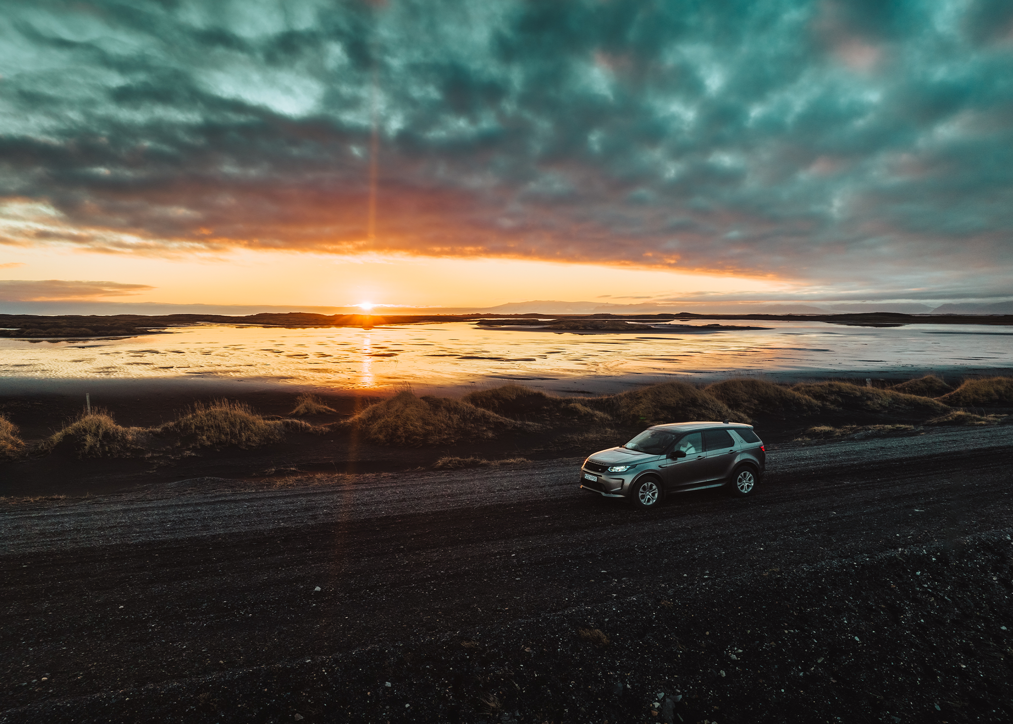 Land Rover Discovery Sport garée sur la route alors que le soleil se couche