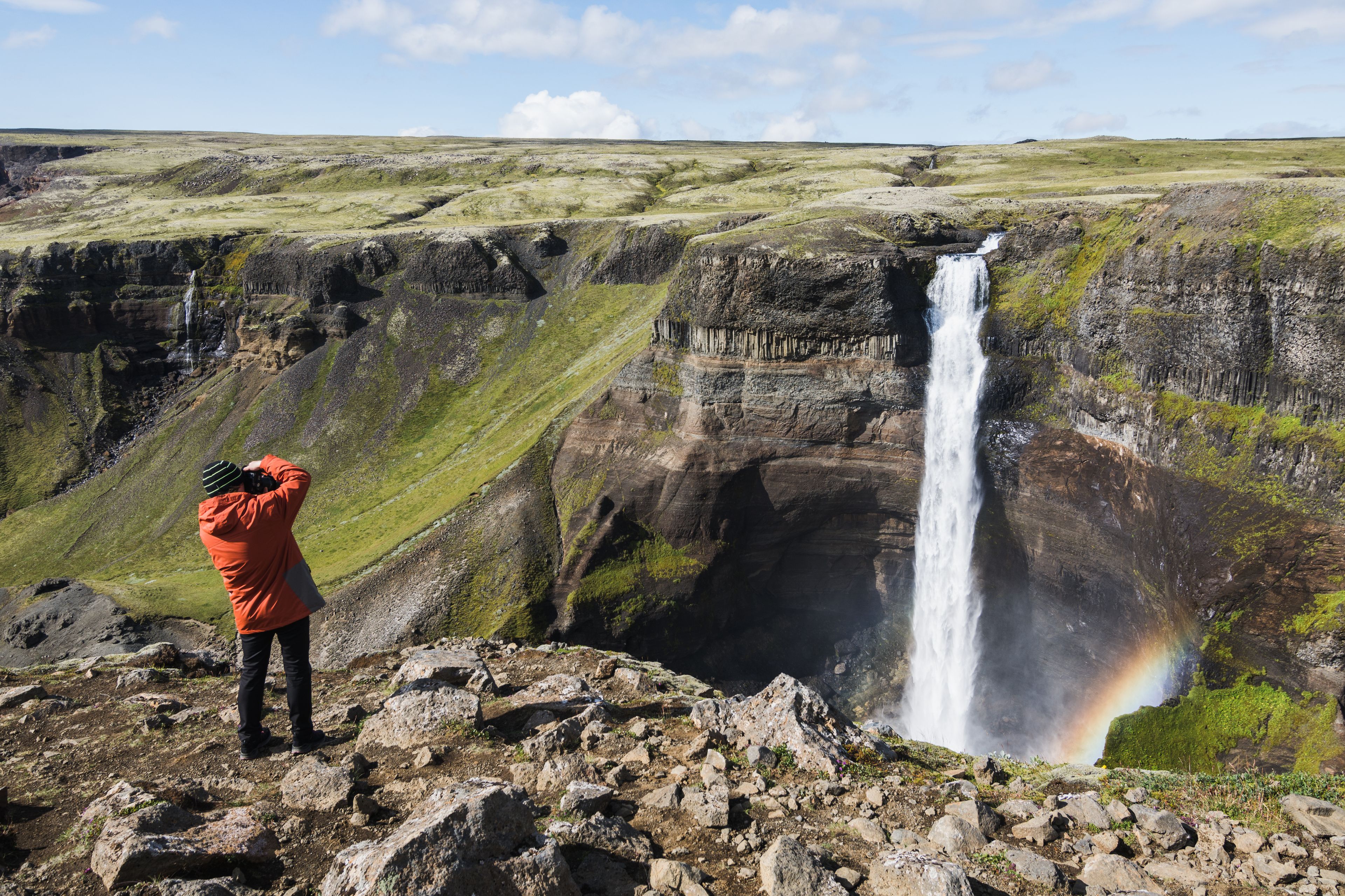 Man taking a picture of Haifoss waterfall from the viewpoint