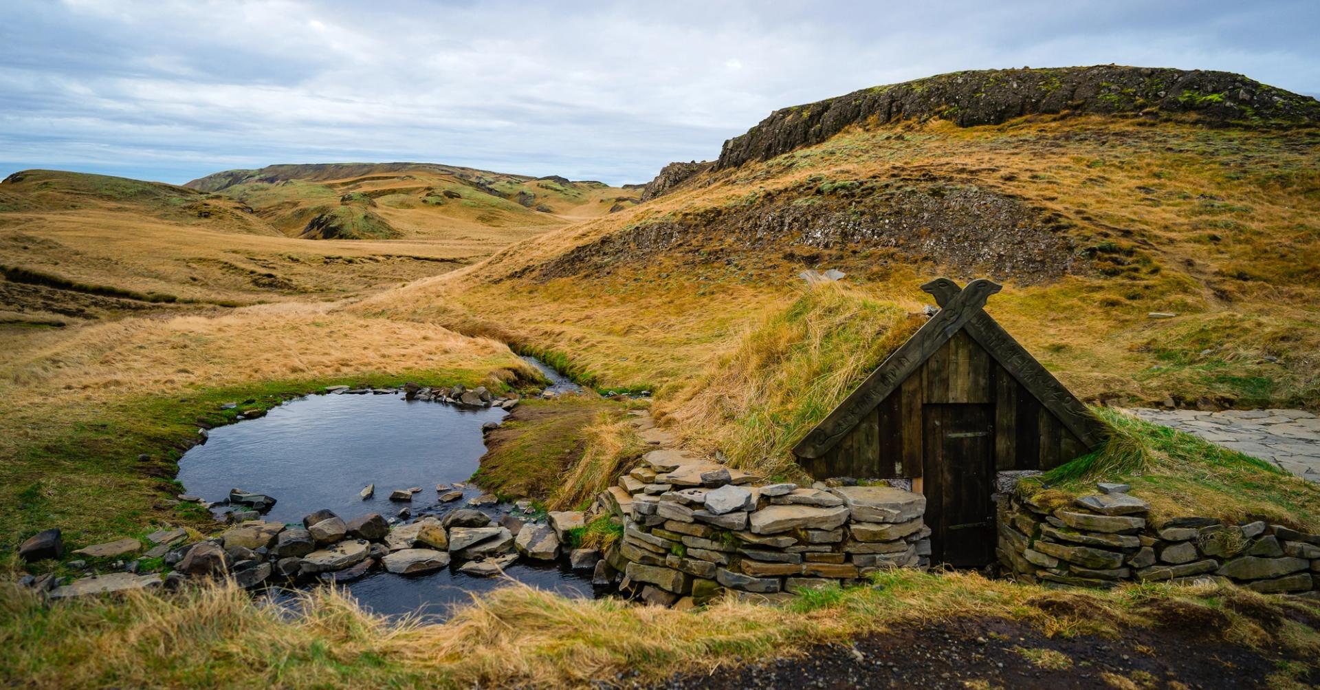 A small hot spring in Iceland with a small turf house next to it. The Hrunalaug Hot Spring.