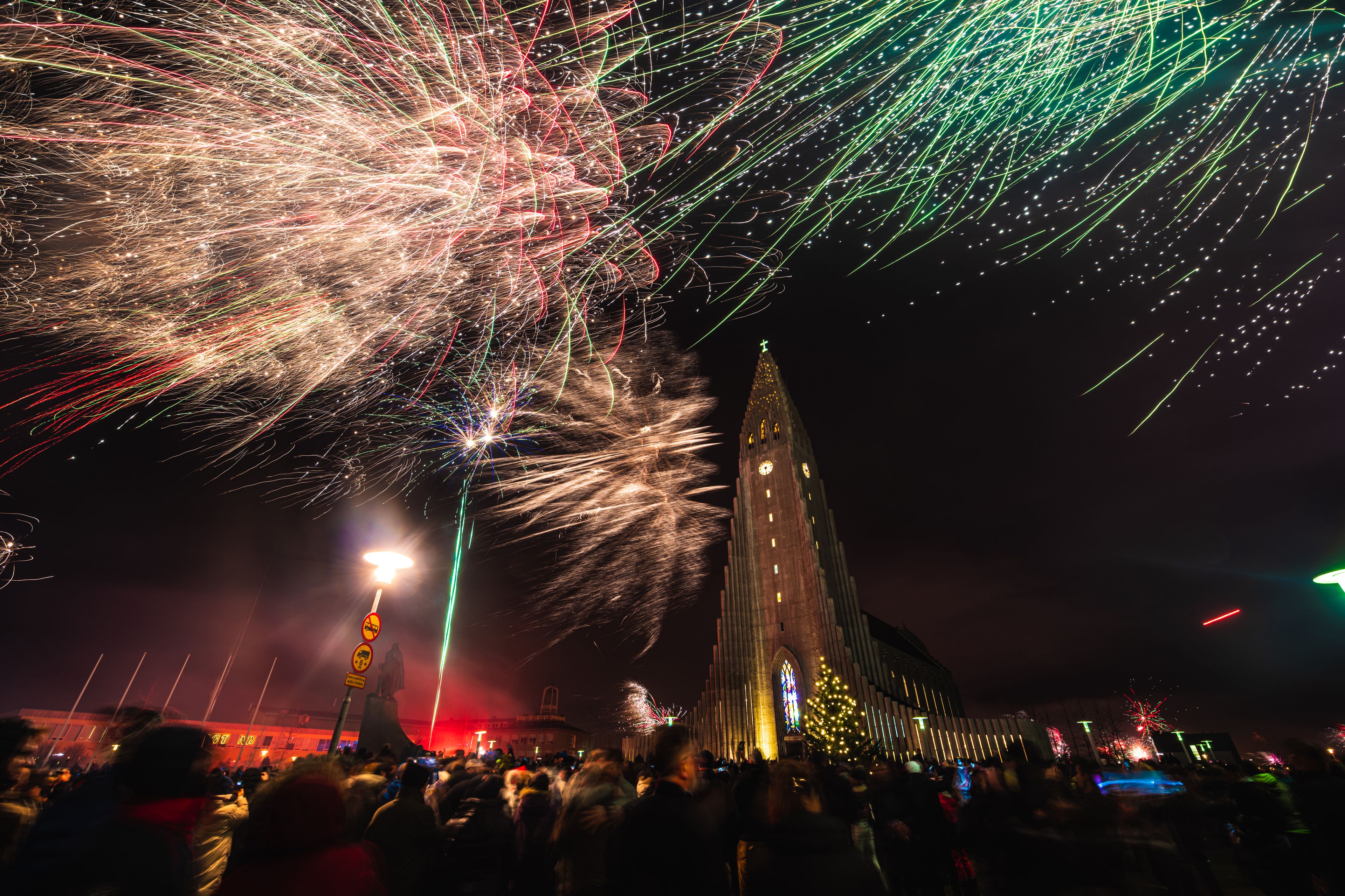 People gathering in Reykjavik to celebrate New Year's Eve with fireworks and music