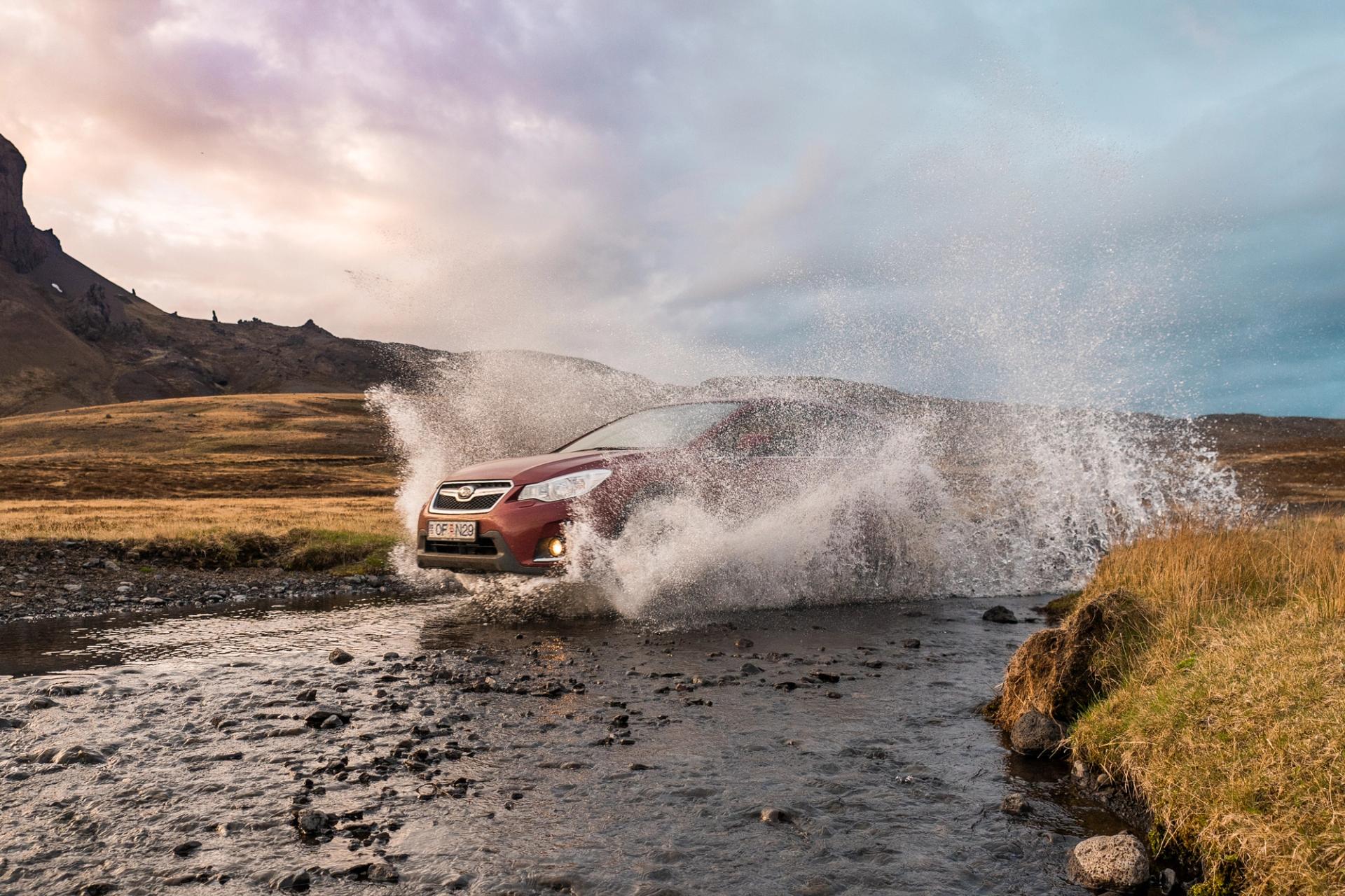 Red 4x4 crossing a river in Iceland 